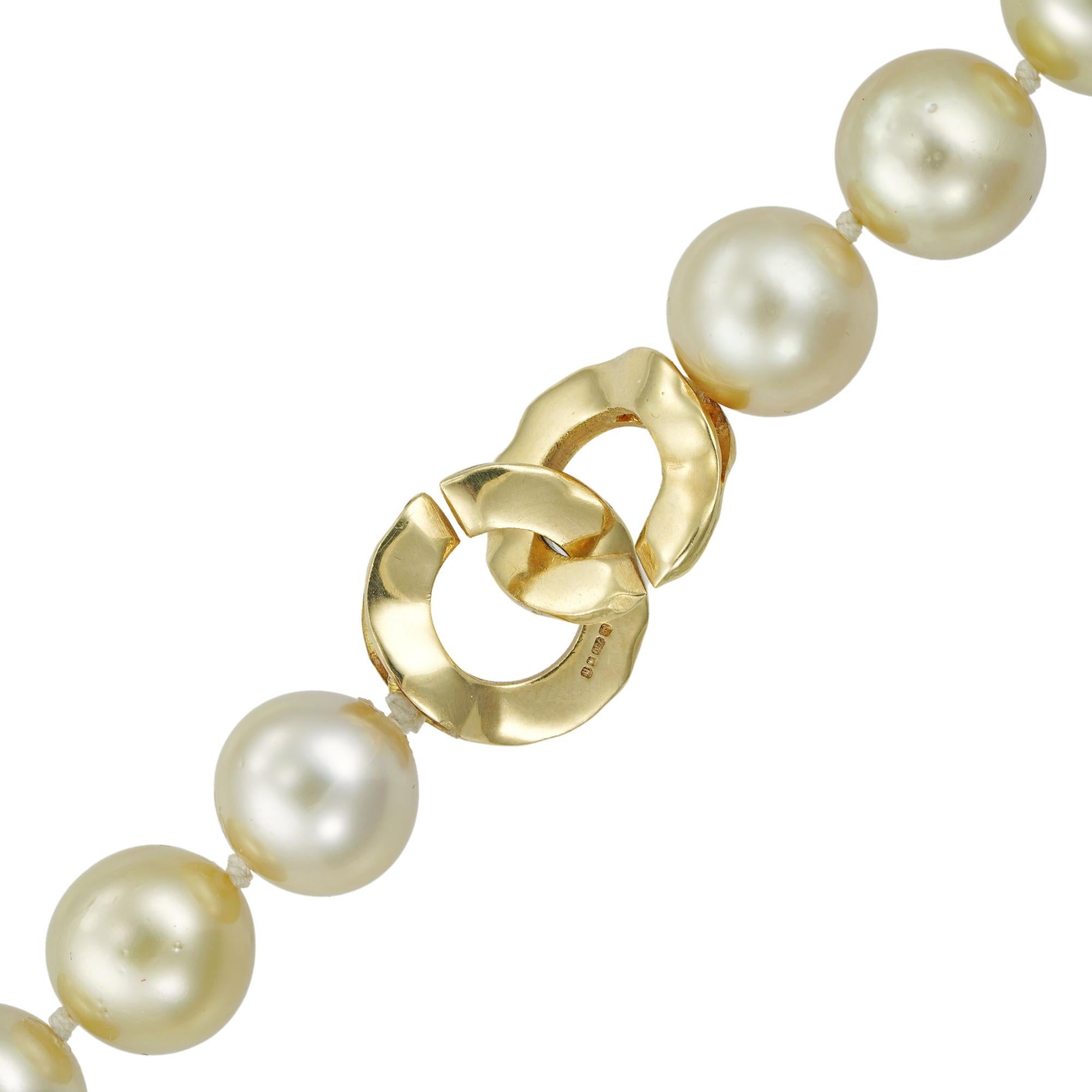 Eine goldfarbene Südsee-Zuchtperlenkette, die neununddreißig Perlen messen 10,5 mm bis 11,5 mm und sind von der Mitte aus abgestuft. Sie sind an einem kreisförmigen gehämmerten Verschluss aus Gelbgold aufgereiht, gestempelt auf 18 Karat Gold, London
