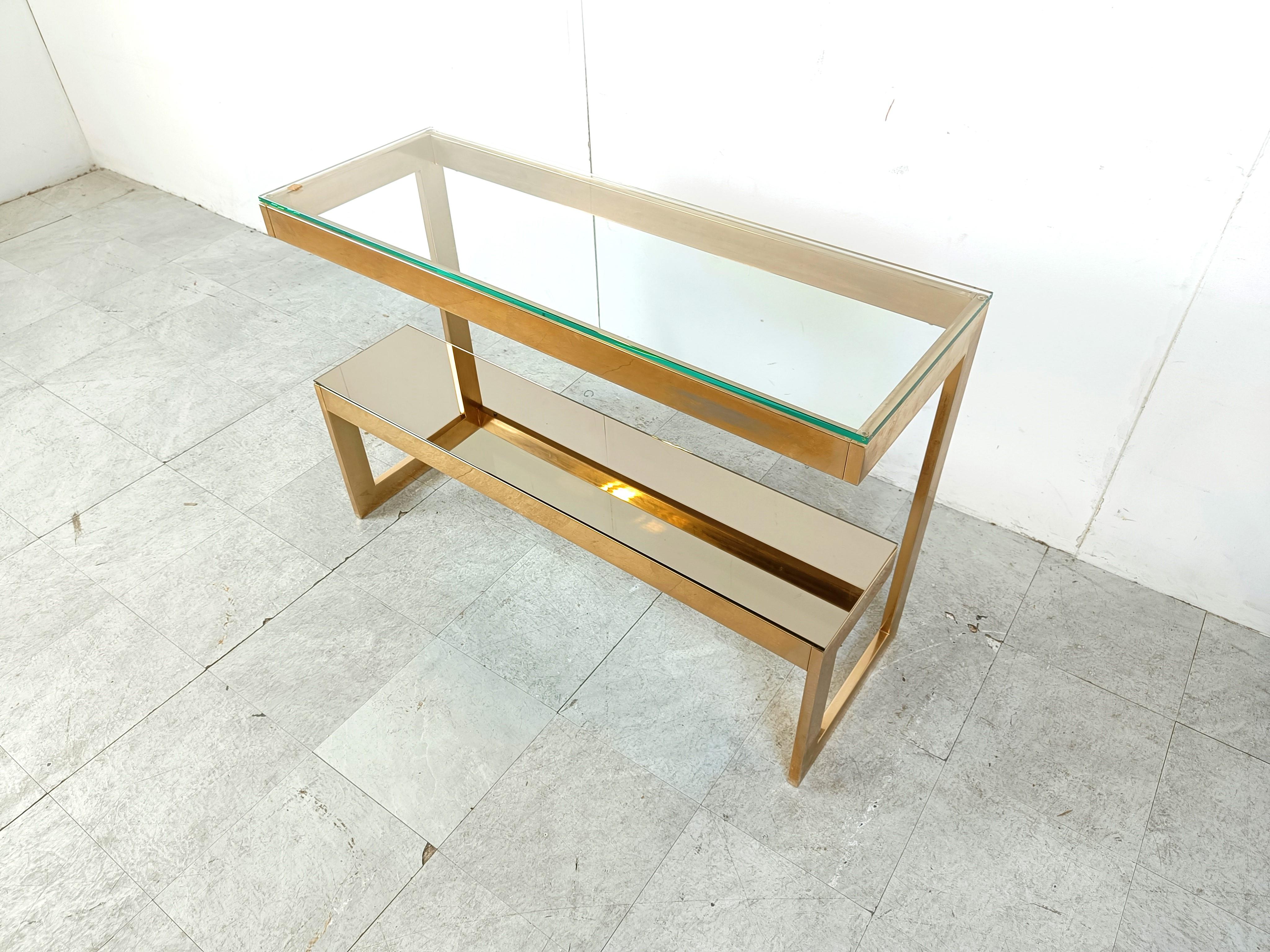 23kt gold layered 'G'-shaped console table produced by Belgochrom.

The table has mirrored and clear glass tops

Good vintage condition with normal age related wear. New glass.

1970s - Belgium

Height: 75cm
Width: 110cm
Depth: 40cm

Ref.: 354444