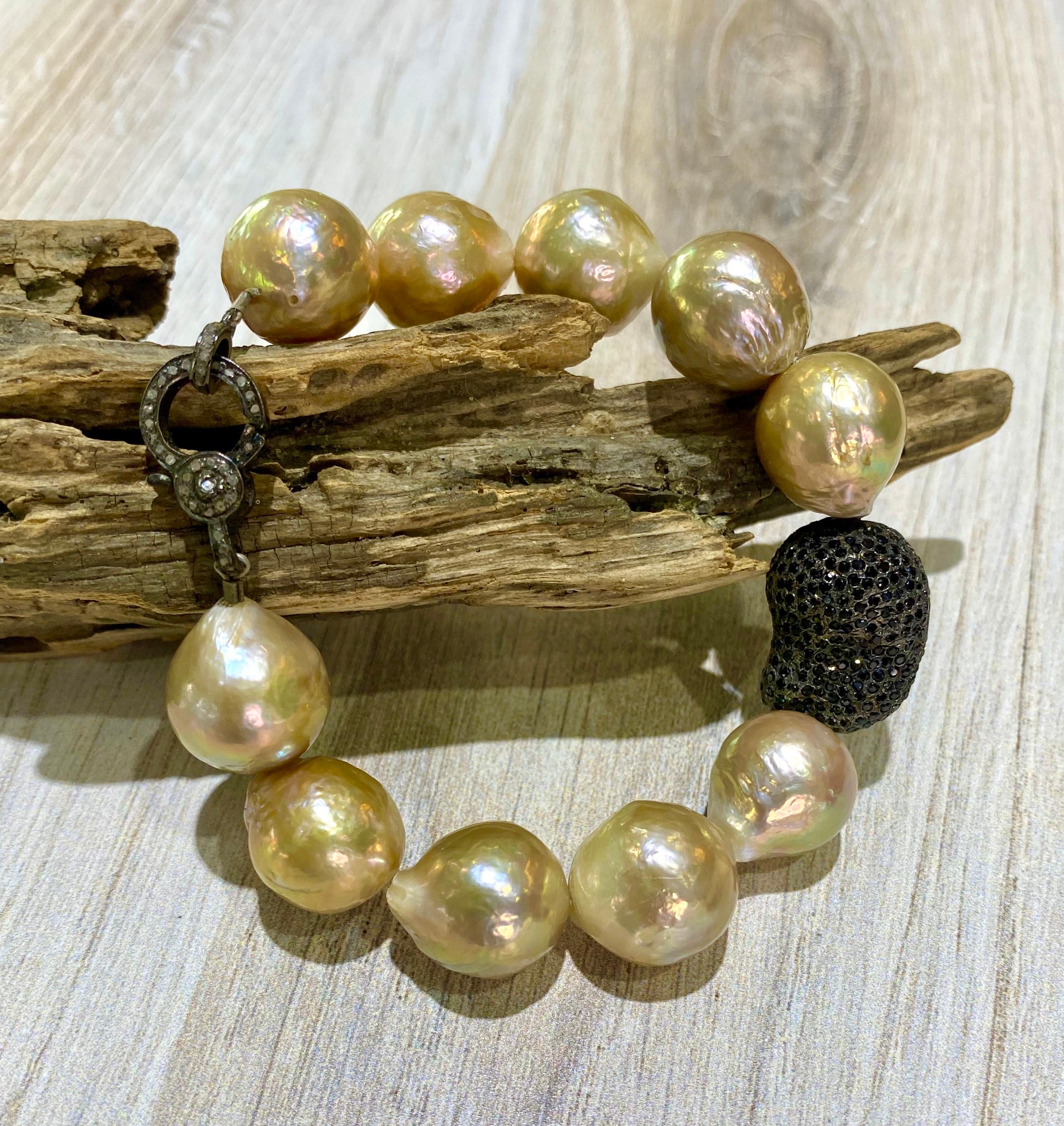 This stunning bracelet is made of naturally gold Edison pearls with an organic, baroque shape.  The pearls are large, 14mm and have a metallic shiny luster.  A big, sparkling black spinel bead is centered and is finished with a champagne diamond