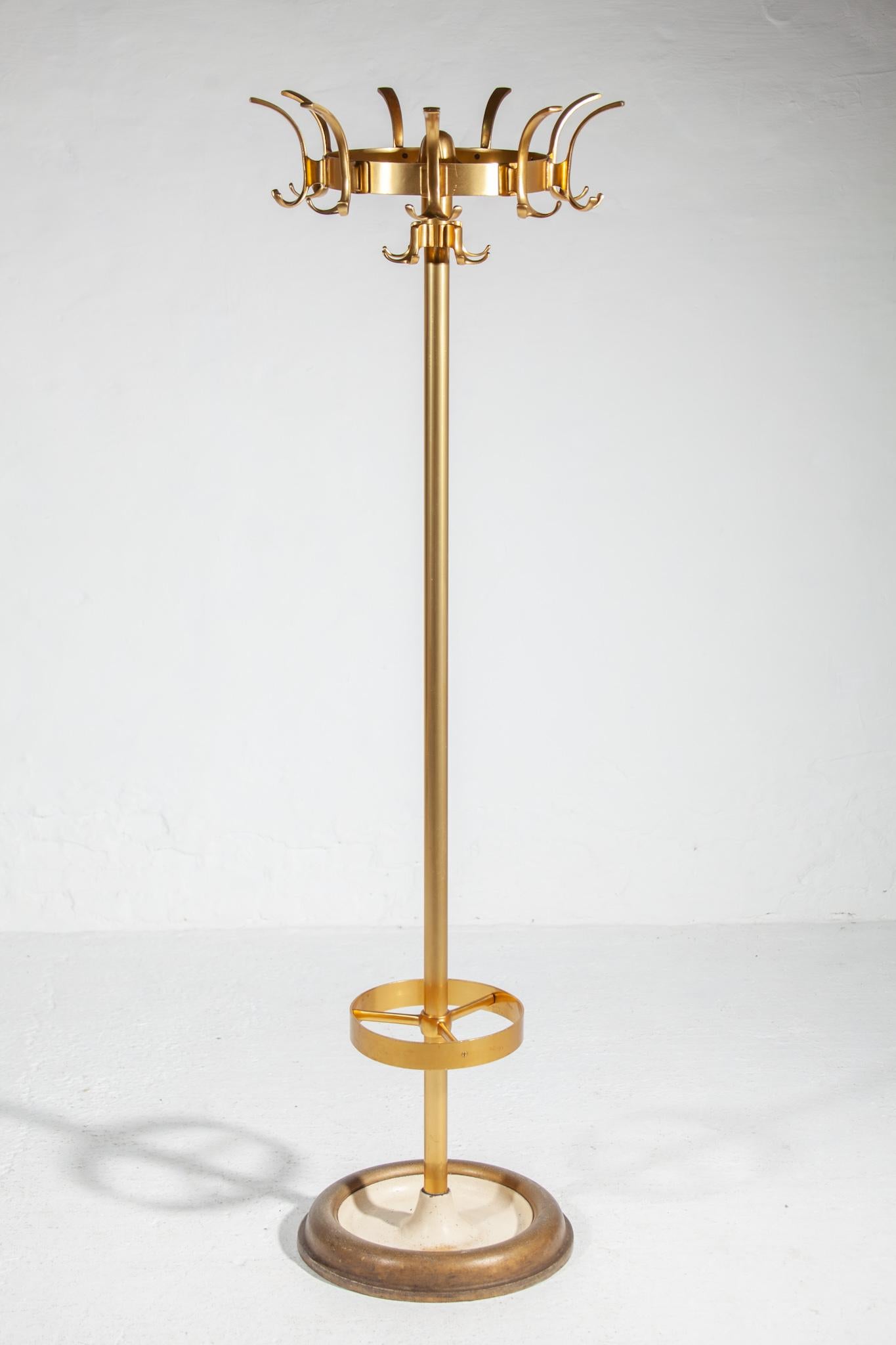 Beautiful fifties coat-rack. Heavy high quality brass aluminium round frame with nine hooks it has the ability to turn around so that you can always find your coat without having to move the stand coat rack and metal base. Made in Germany. In