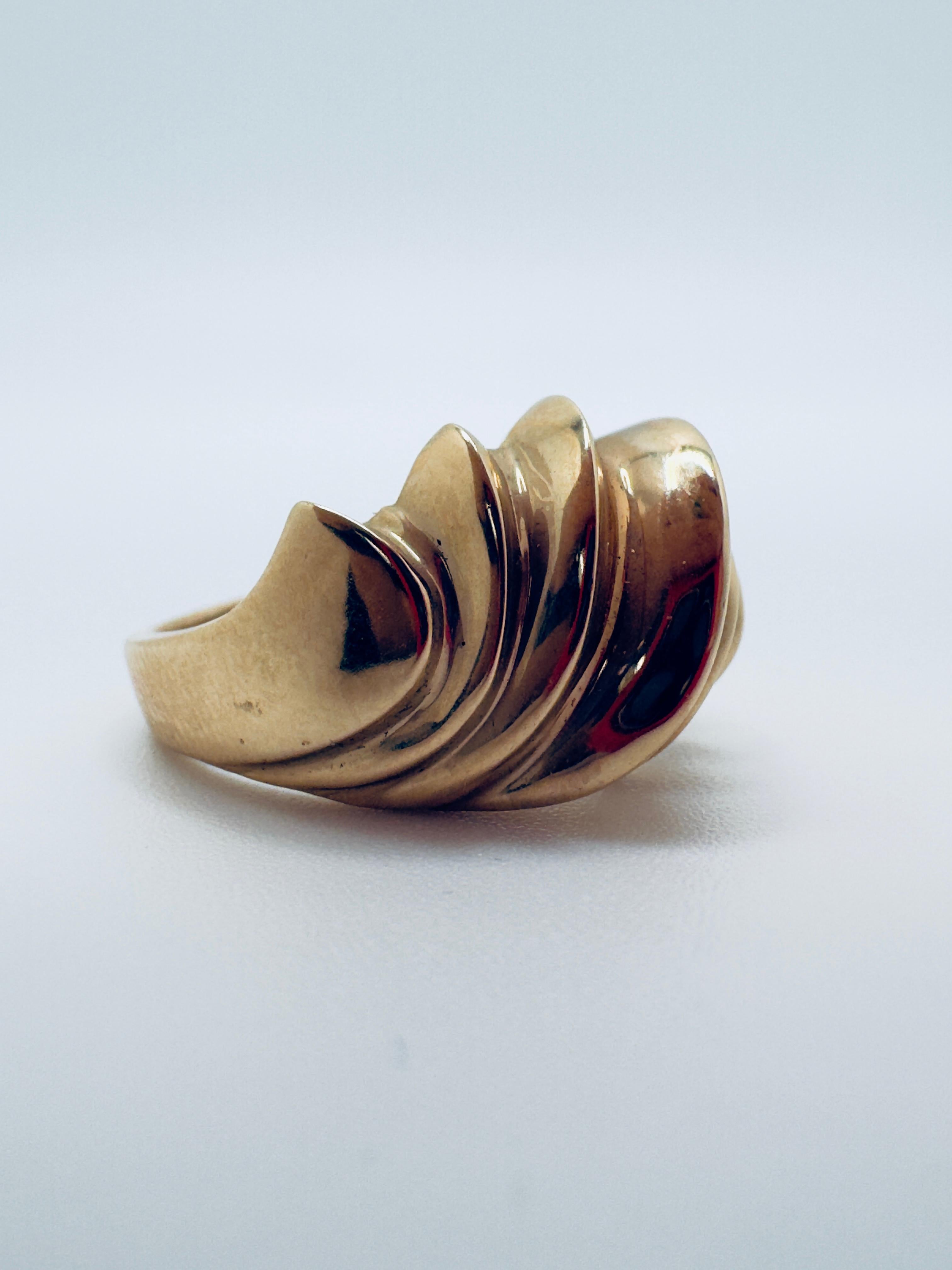 Questo caratteristico anello è splendidamente realizzato in oro giallo 14K e disegnato con uno stile artistico a forma libera. L'esclusivo motivo a 