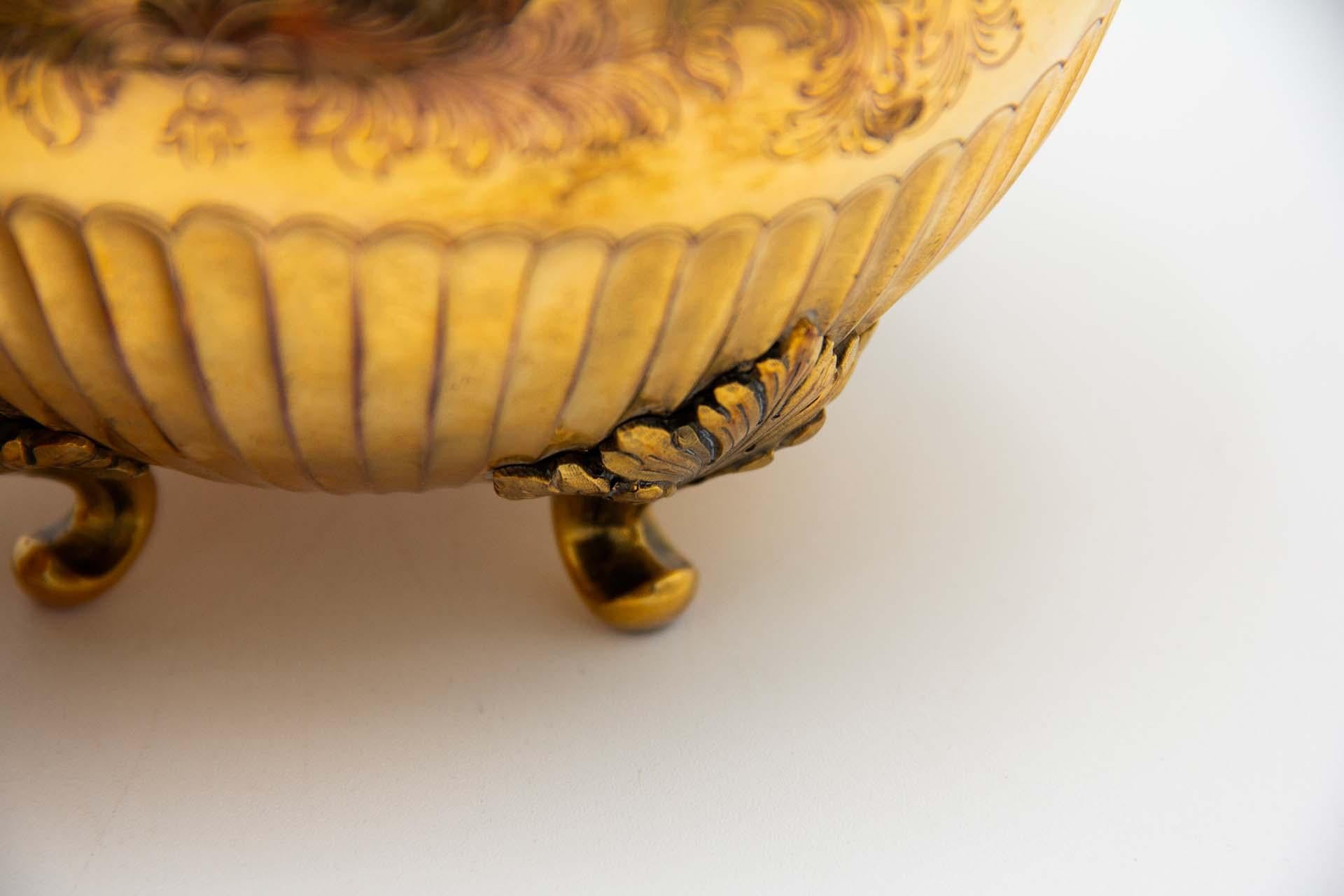 Descrizione: Scatola scanalata in argento con finiture dorate, con doppi manici a forma di frutta e poggiata su quattro piedi a foglia d'acanto. Metallo: Argento. Origine: Portoghese. Marchio: aquila in piedi. Peso: 495,87 grammi. Dimensioni: