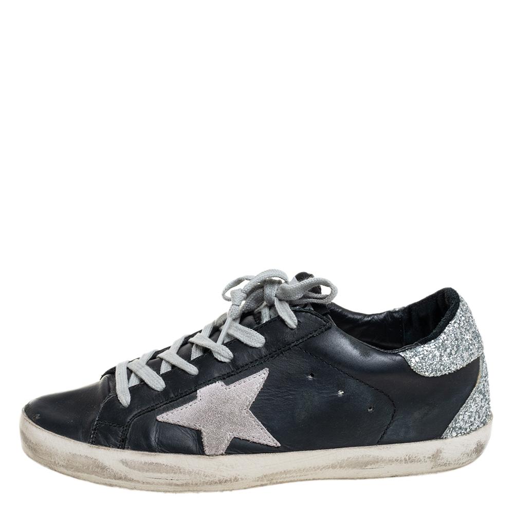 Enjoy footwear ease with this pair of low-top Superstar sneakers by Golden Goose. These Superstar sneakers have been crafted from glitter and leather and designed with round toes, lace-up on the vamps, star patches on the sides, and logo details on