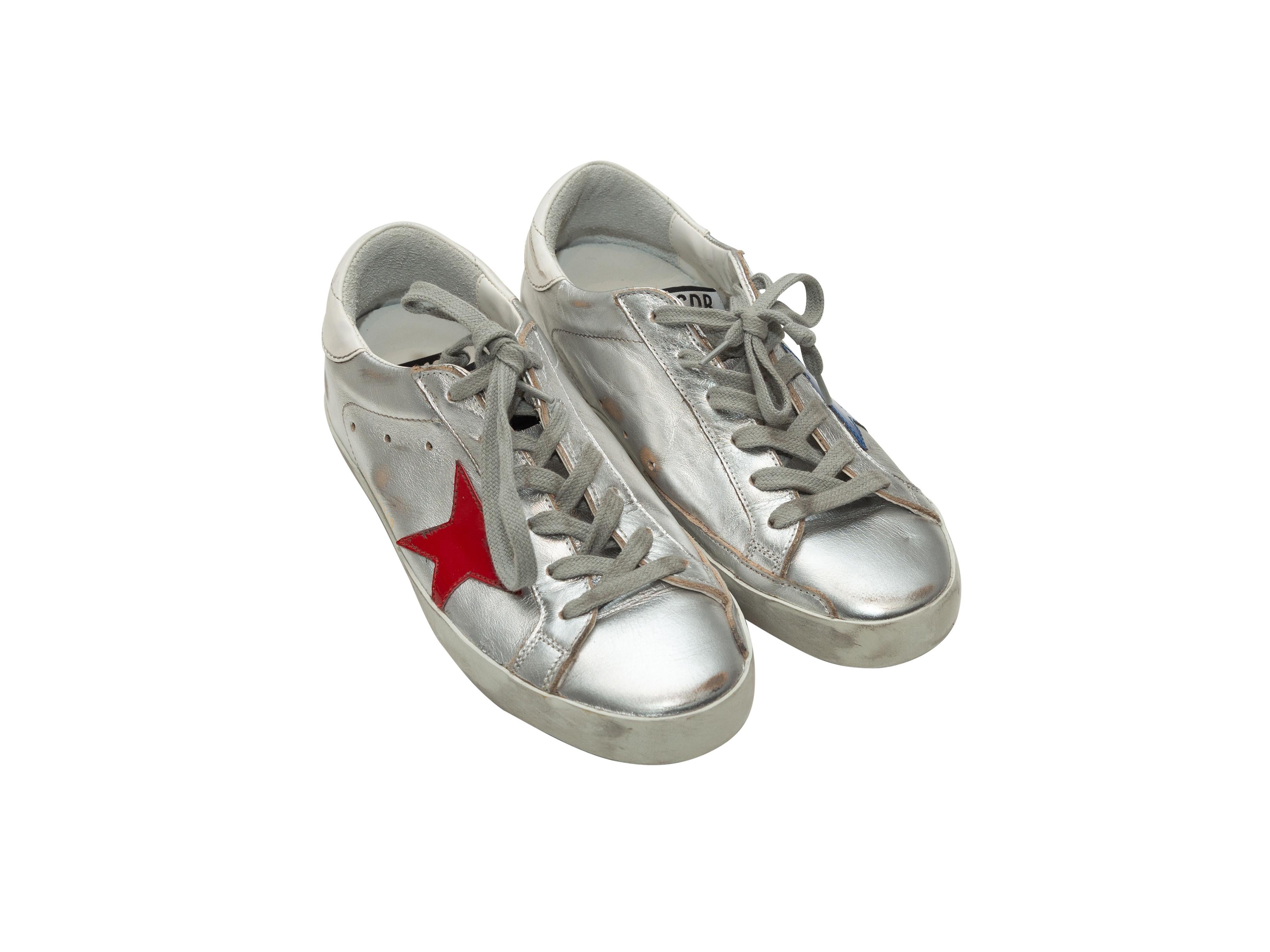Product details: Silver, red, blue and white leather low-top distressed sneakers by Golden Goose Deluxe Brand. Lace-up tie closures at tops. Designer size 37.
Condition: Pre-owned. Very good. Slight creasing at toes.