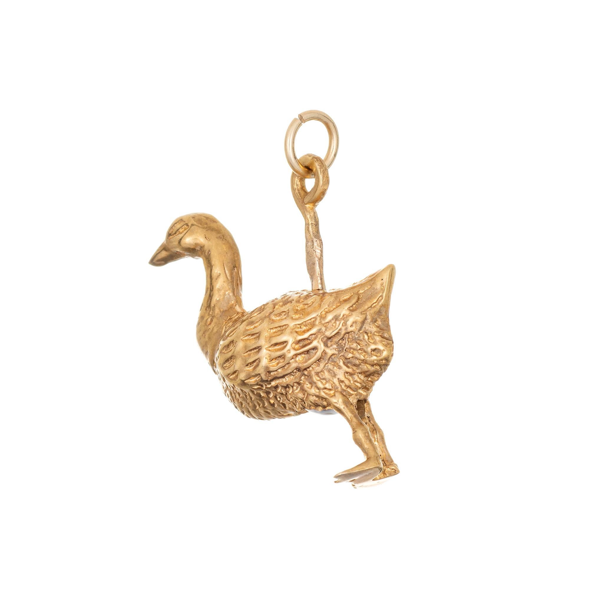 Fein gearbeiteter Vintage-Goose-Charme aus 14 Karat Gelbgold. 

Das kleine Keramik-Ei misst 5 mm x 3,5 mm.

Die wunderschön detailliert gestaltete Gans verfügt über einen Hebel, der sich zum Legen des Eies auf und ab bewegt. Der Charme eignet sich