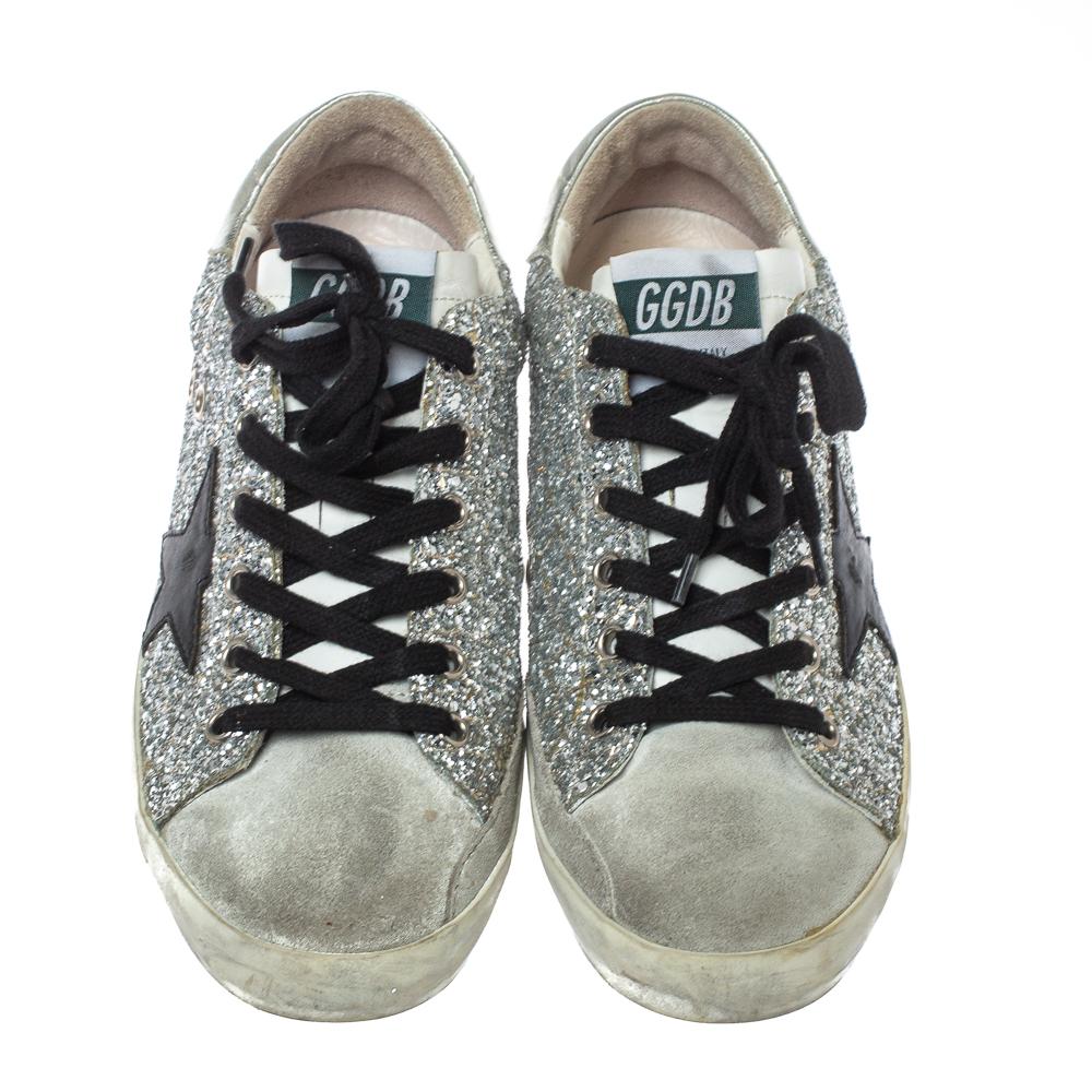 Enjoy footwear ease with this pair of sneakers by Golden Goose. They've been crafted from silver glitter and suede and designed with round toes, lace-up on the vamps, and star patches on the sides. The leather insoles and rubber outsoles add to the