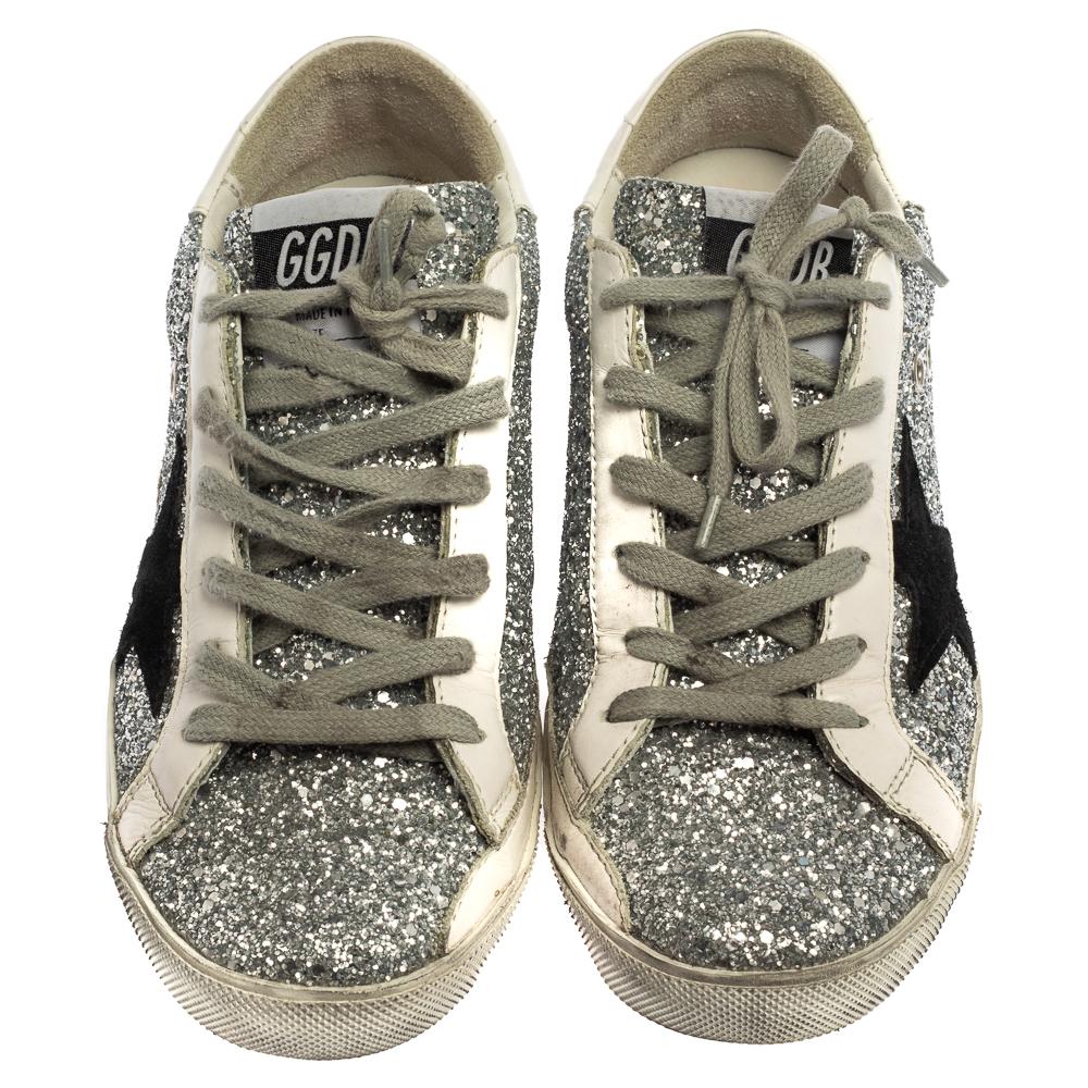 Enjoy footwear ease with this pair of sneakers by Golden Goose. They've been crafted from silver glitter and white leather and is designed with signature star appliques on the sides, round toes, and lace-up on the vamps. The leather insoles and