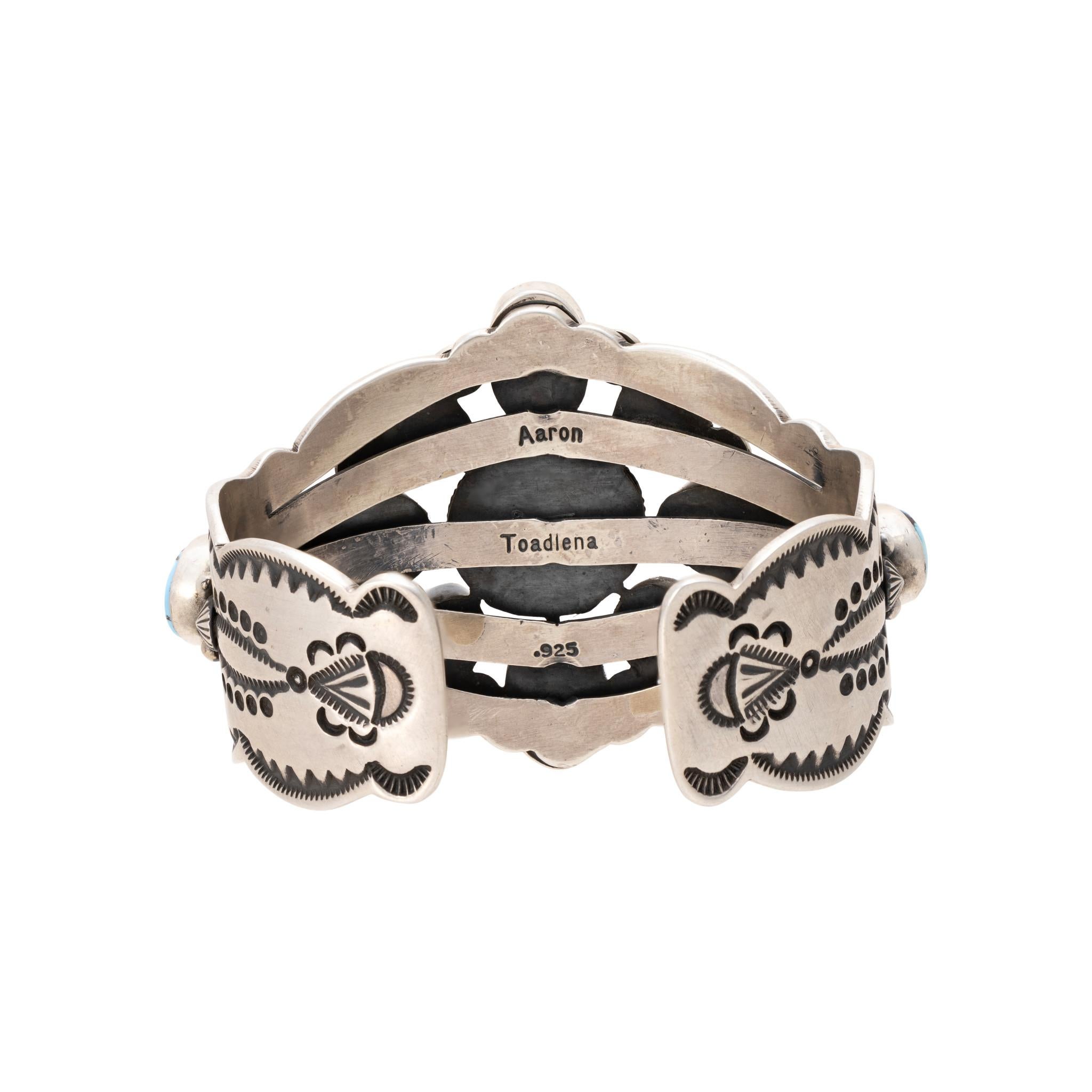Navajo Golden Hill turquoise and sterling silver bracelet by Navajo Silversmith Aaron Toadlena. Deep blue stones with various degrees of depth surrounded by twisted rope border on a band of hand stamped designs. Stamped sterling with maker's