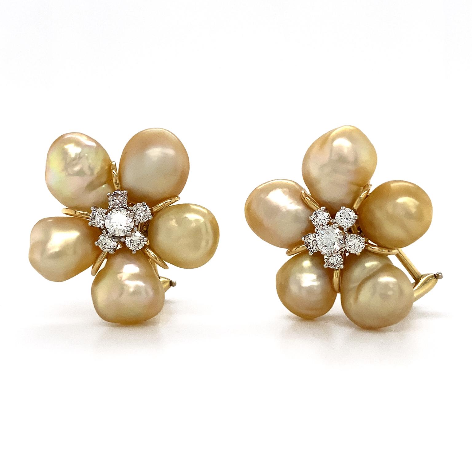 Flowers illustrated in gold toned Keshi pearls. Five pearls form a cluster, producing a delicate warm luster at every angle. Their 18k yellow gold settings provide another flicker of warm light. At the center five brilliant cut diamonds surround a