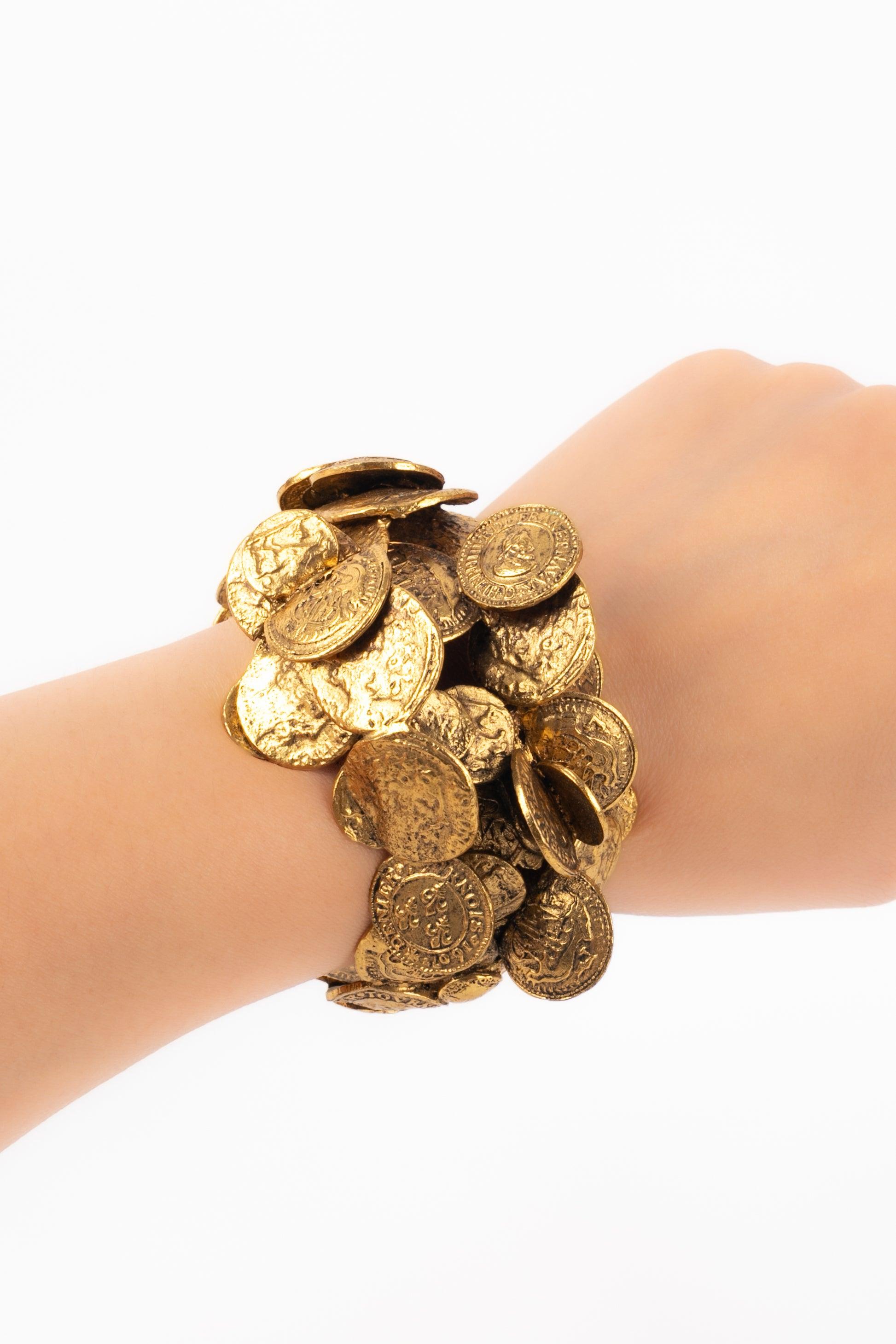 Pulsera de monedas de metal dorado.

Más información:
Estado: Buen estado
Dimensiones: Longitud: 15 cm - Abertura: 3 cm

Referencia del vendedor: BRA10