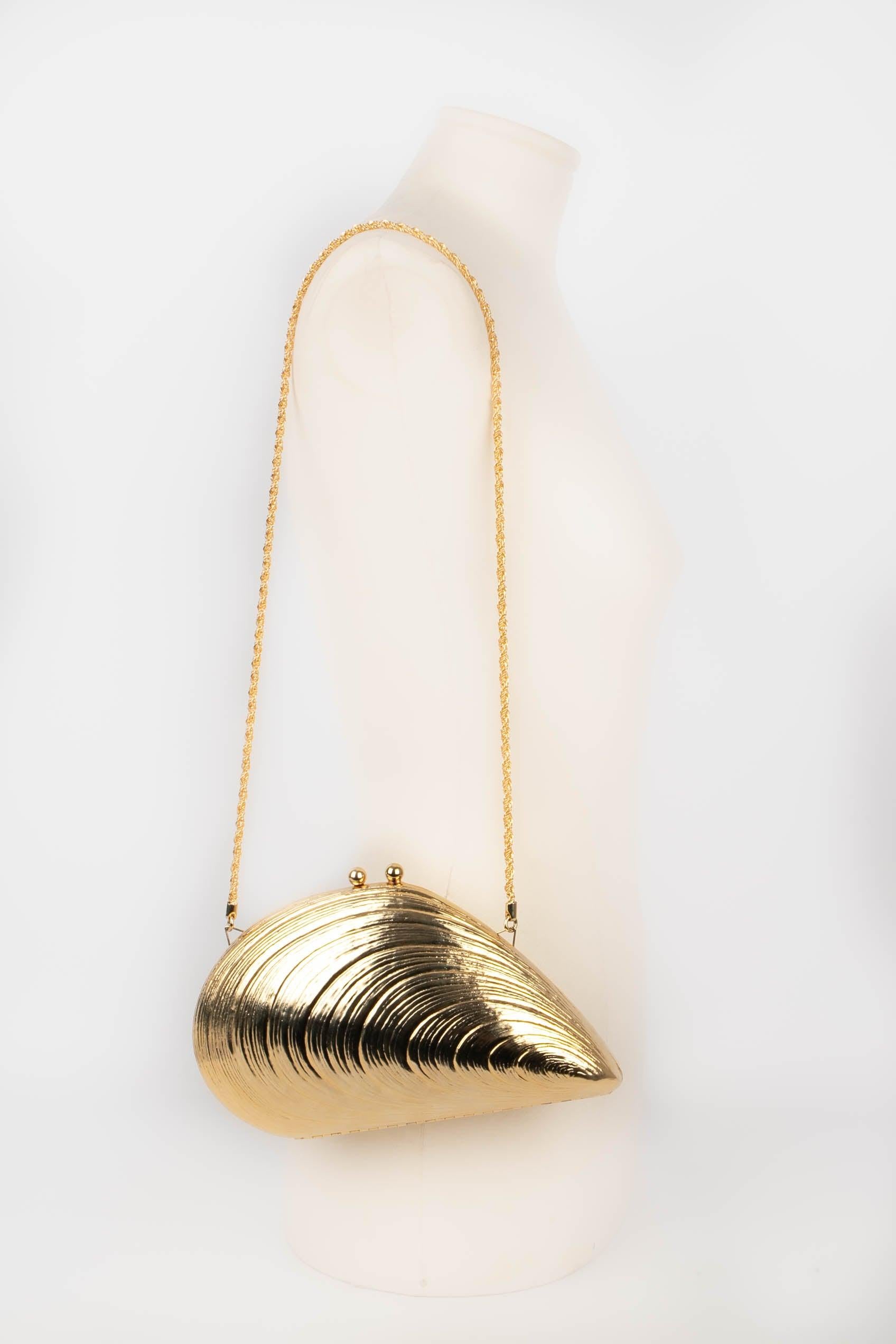 Fortuna - (Made in Italy) Golden metal seashell bag. Interior ornamented with beige suede. Snap fastener.

Additional information:
Condition: Very good condition
Dimensions: 23 cm x 16 cm

Seller Reference: S230