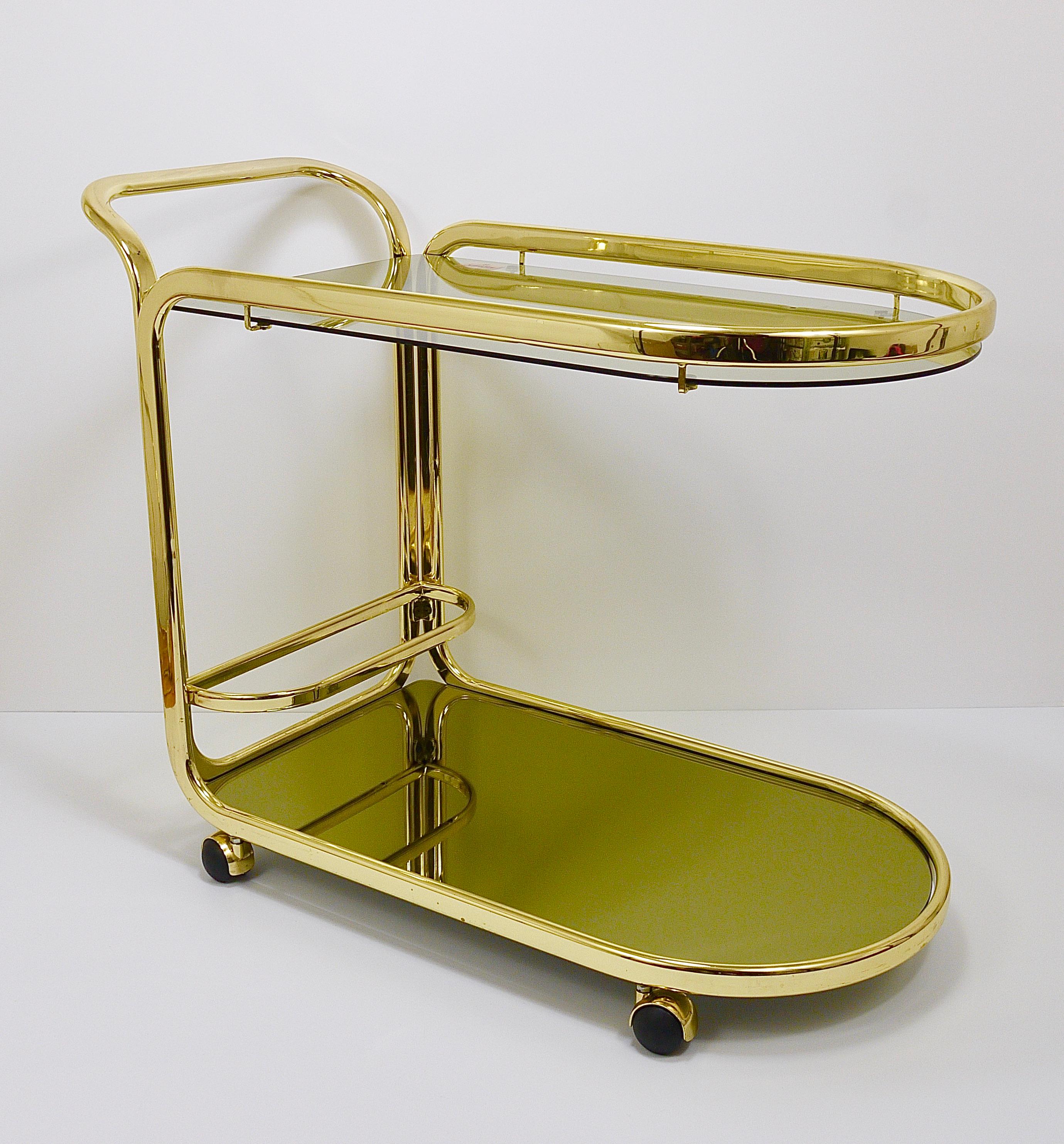 A wonderful Hollywood Regency two-tier bar cart/ drinks serving trolley on wheels from the 1970s. Designed and manufactured by Morex Italy. A beautiful Midcentury piece, made of gilded tubular metal with two levels, the upper one is made of grey