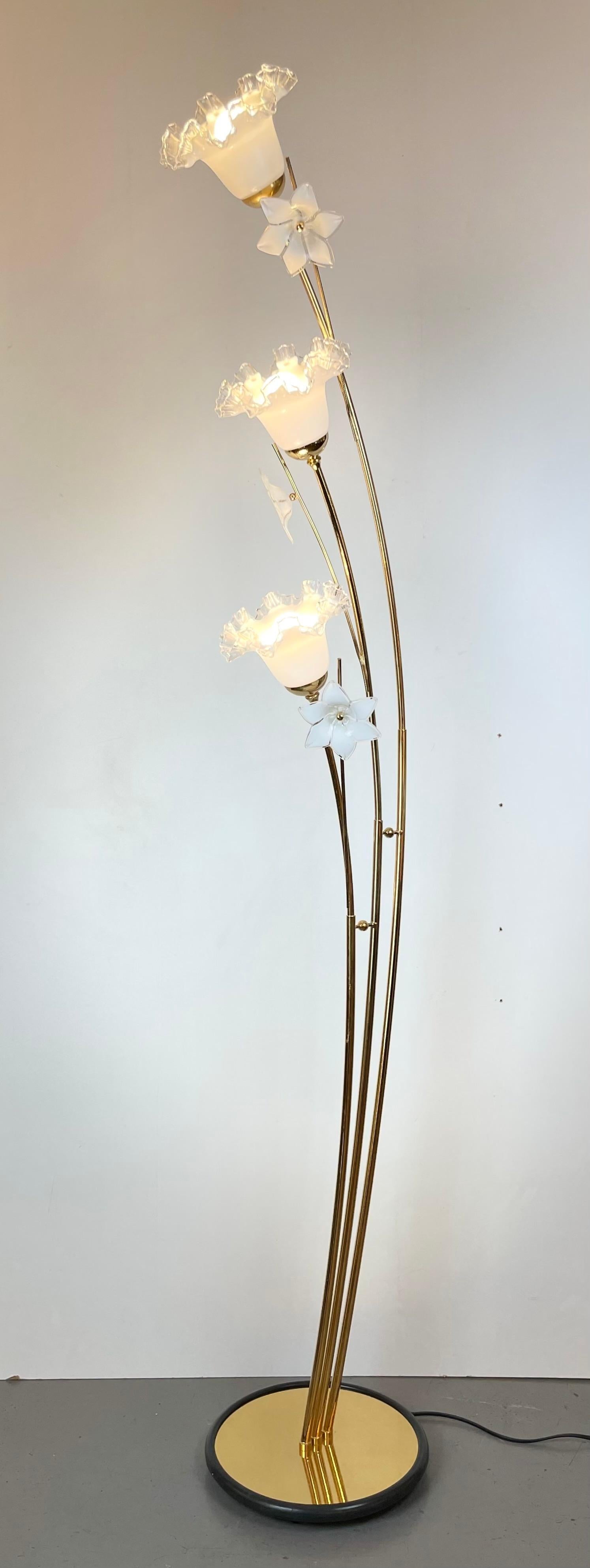 Lámpara de pie italiana con estructura de metal dorado con tres ramas y flores blancas de cristal de Murano, acompañadas de una goma negra alrededor de la base redonda. Diseño en Venecia en la década de 1980.
-
Producido en: Isla de Murano
Origen:
