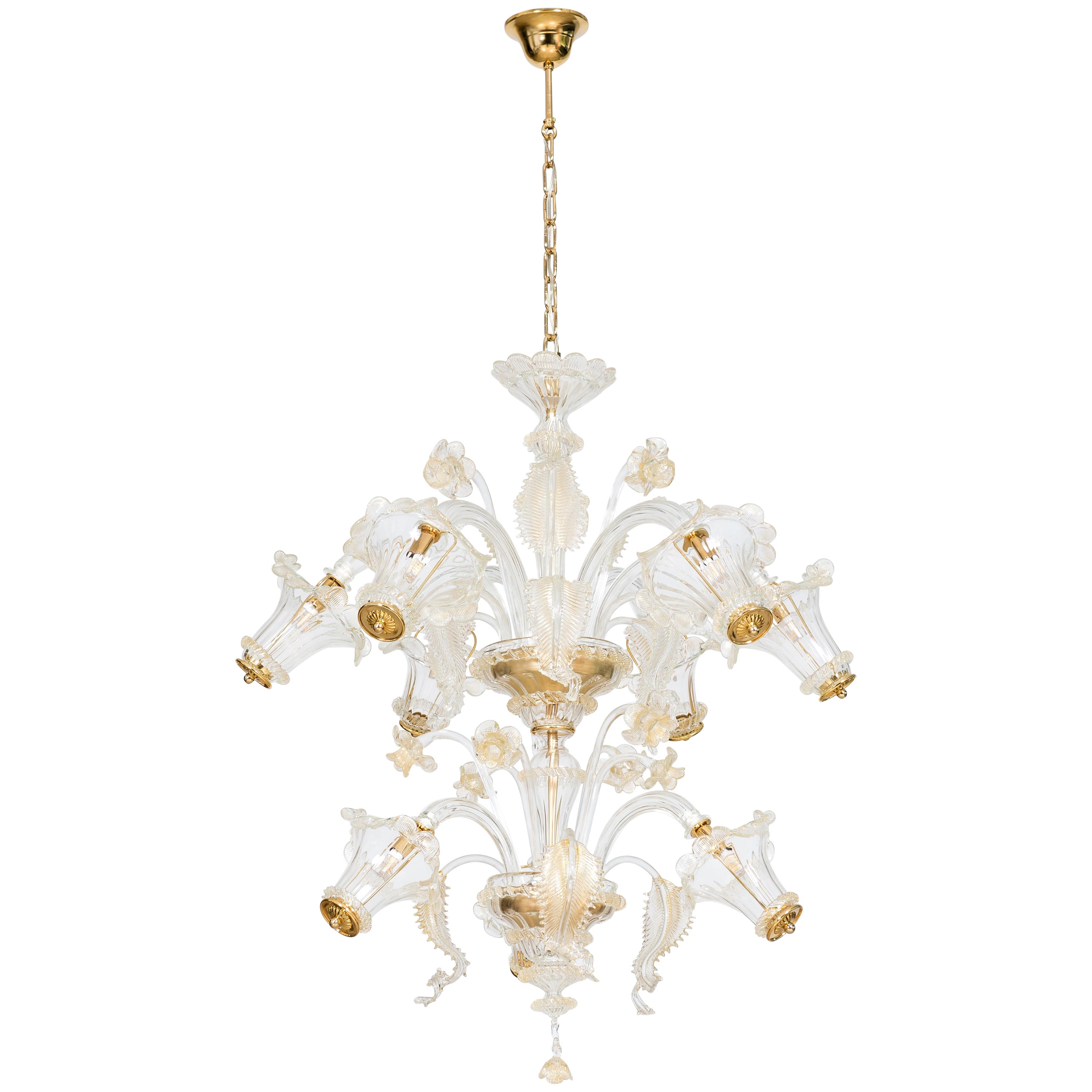 Lustre à 9 lumières en verre doré de Murano, 21e siècle, Italie.
Ce lustre unique se distingue par sa beauté, son élégance et le raffinement de ses détails. 
Deux jardins raffinés de feuilles et de fleurs transparentes et dorées, placés à deux