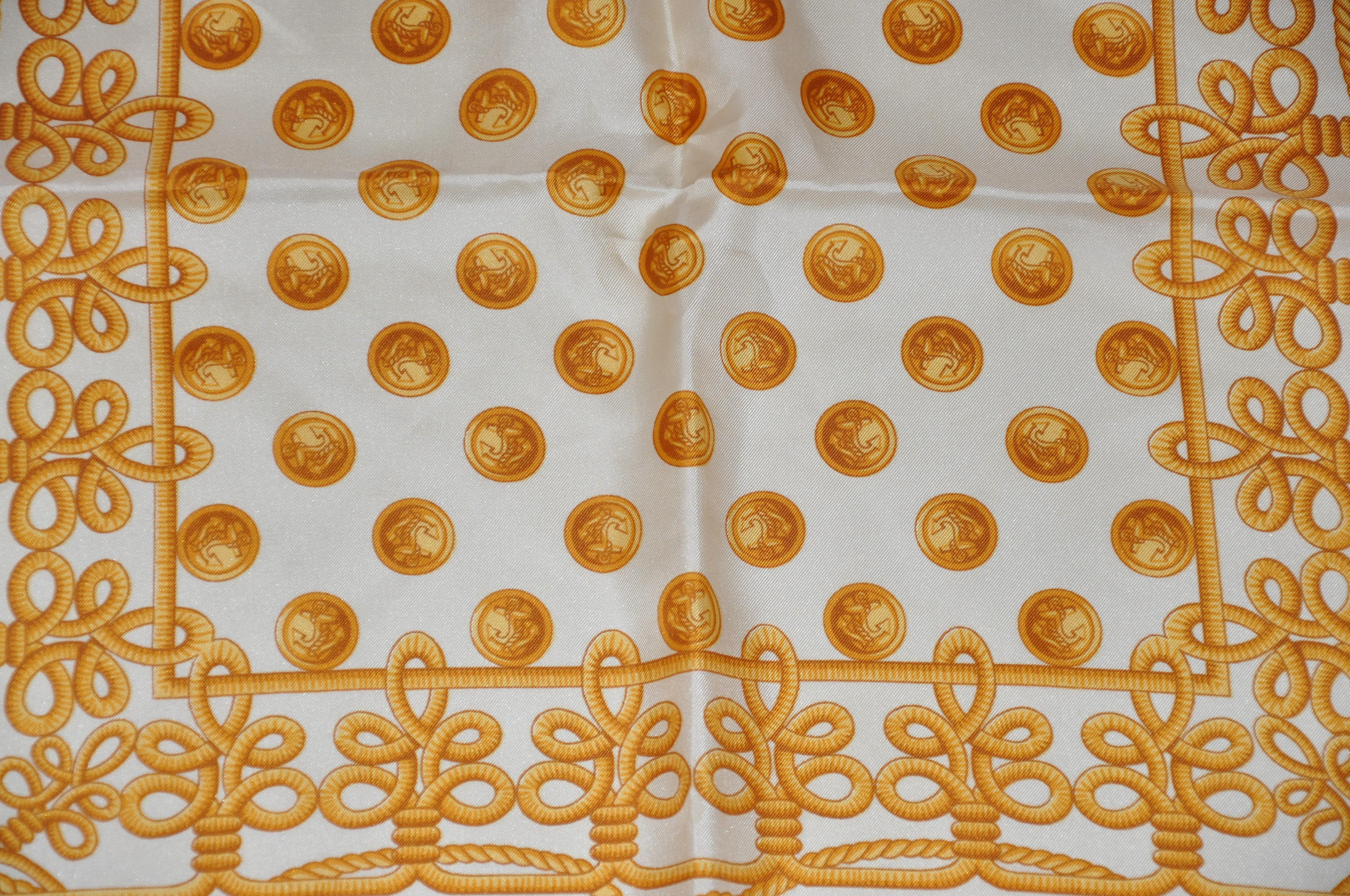This wonderfully vivid and bold golden navel ribbons and brass buttons silk scarf is finished with hand-rolled edges and measures 34 inches by 35 inches. Made in Italy.