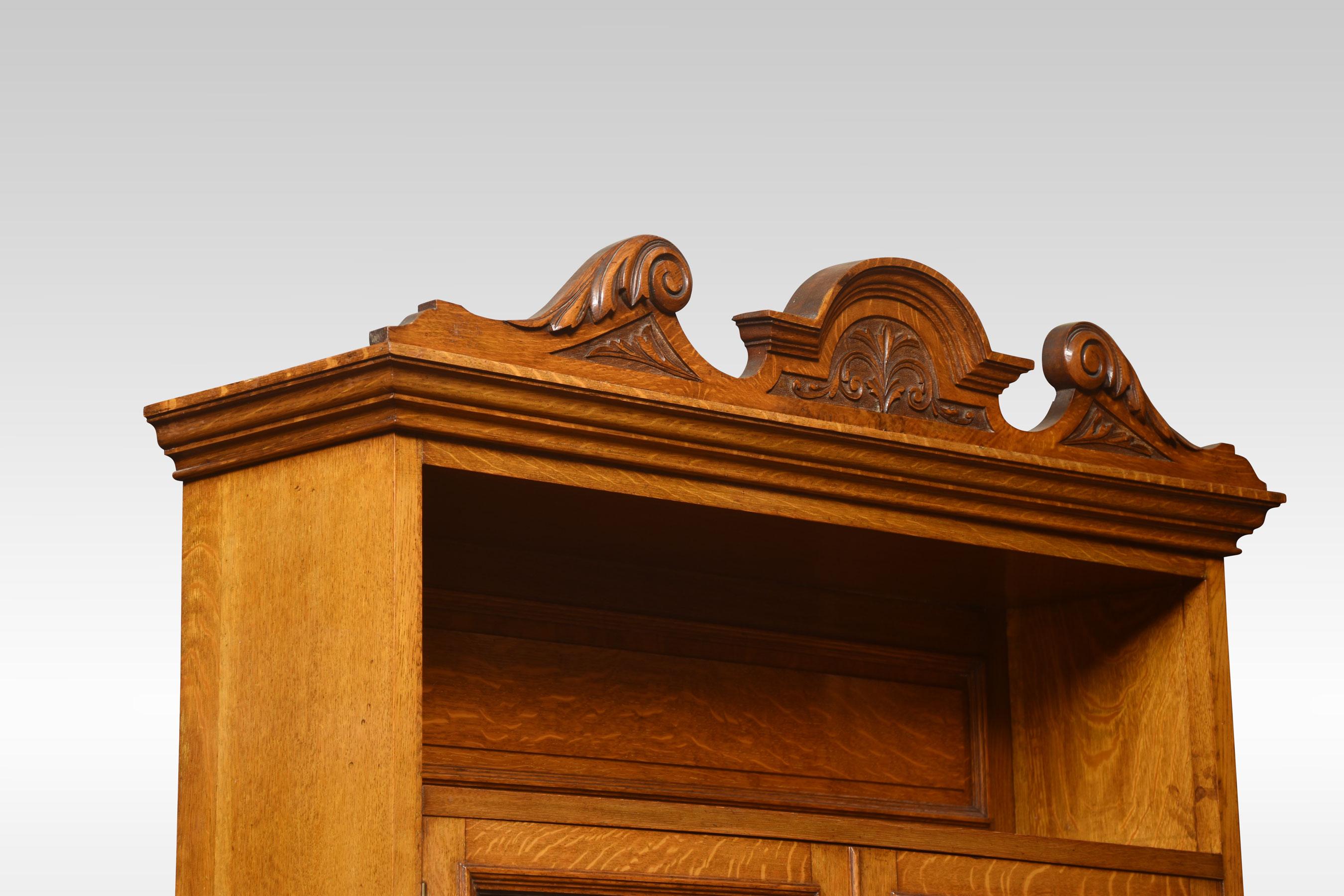Golden oak cabinet, the carved moulded cornice above two leaded glazed doors. Above a bevelled mirror back. To the base section with large freeze drawer and a pair of carved cupboard doors below. All raised up on plinth base.
Dimensions
Height 84