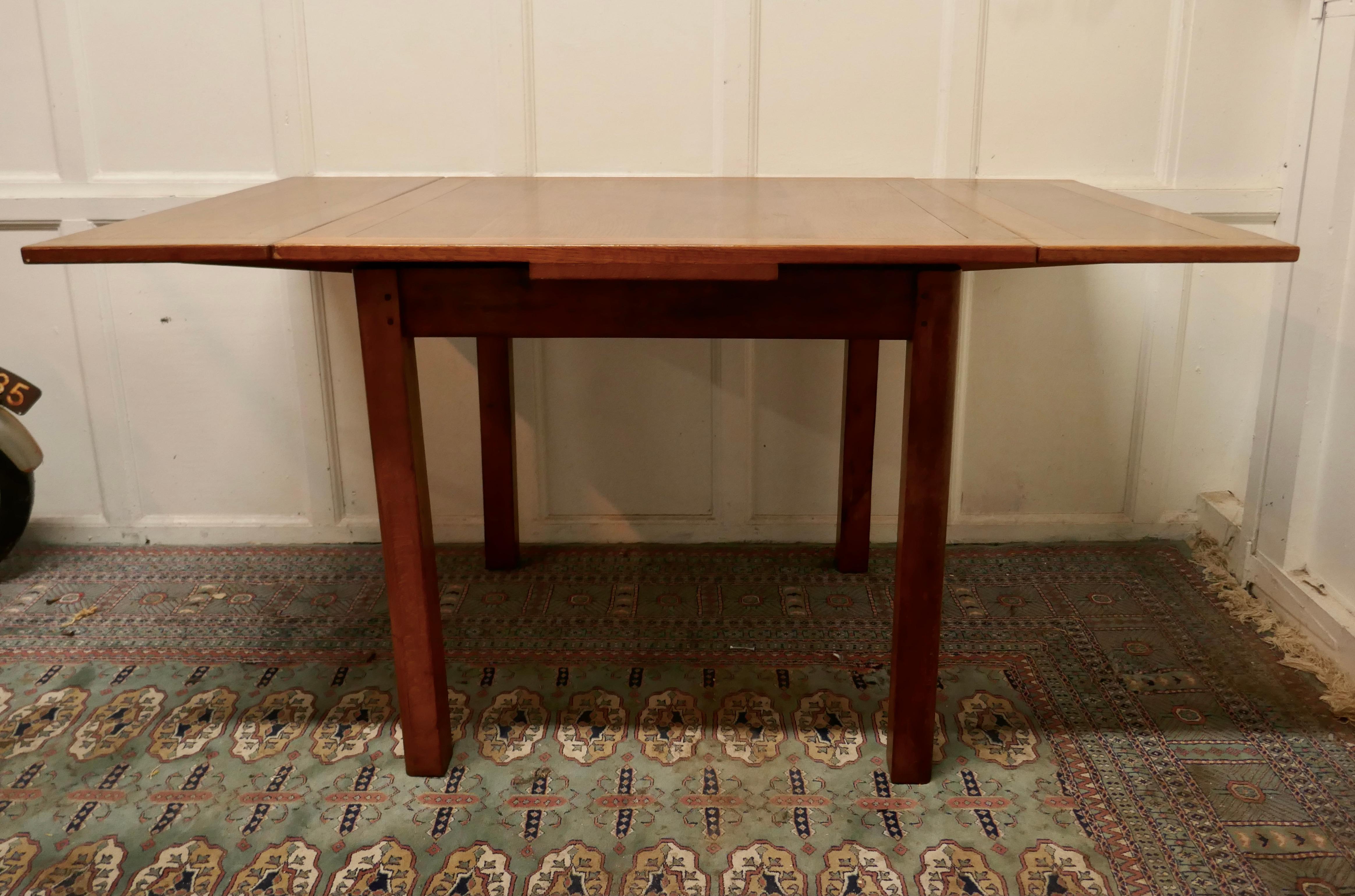 Golden oak cottage draw leaf table

This is a small size piece, the square table has a pull out leaf at each end, so in addition to being used for 4 it can also be used as an 8 seat dining table 
The table is in very good sound condition, there