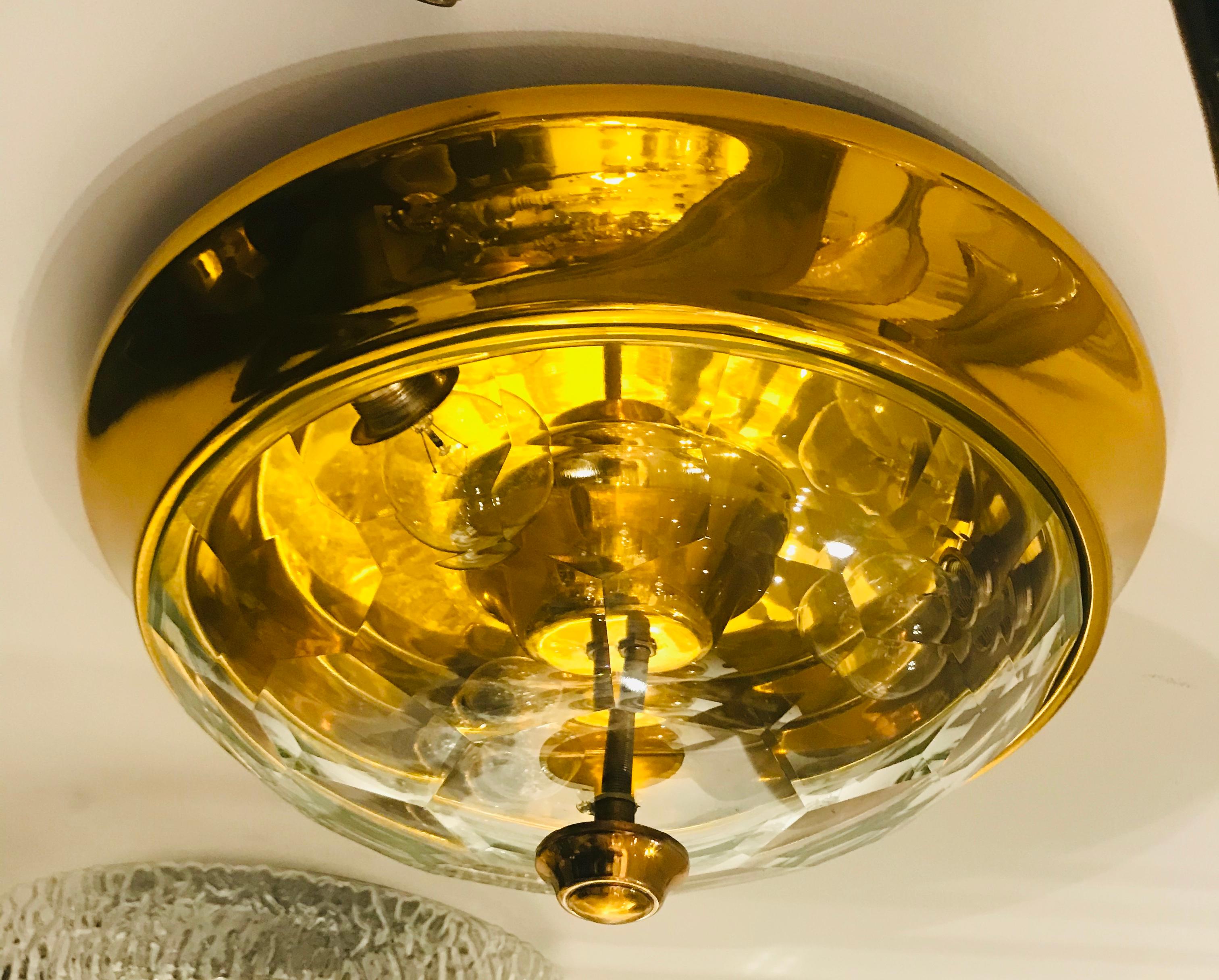 A wonderful 1970s Italian golden brass ceiling light with a thick faceted crystal shade designed by famed designer, Oscar Torlasco for Lumi.