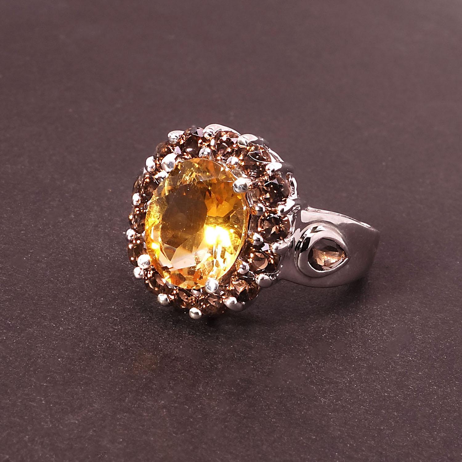 Individuell gestalteter Cocktailring aus funkelndem ovalen goldenen Citrin mit einem Halo aus Rauchquarz.  Zwei weitere Rauchquarze schmiegen sich in die Schultern des Sterling Silber Ringschaftes.  Dieser einzigartige Ring ist ein echter Hingucker