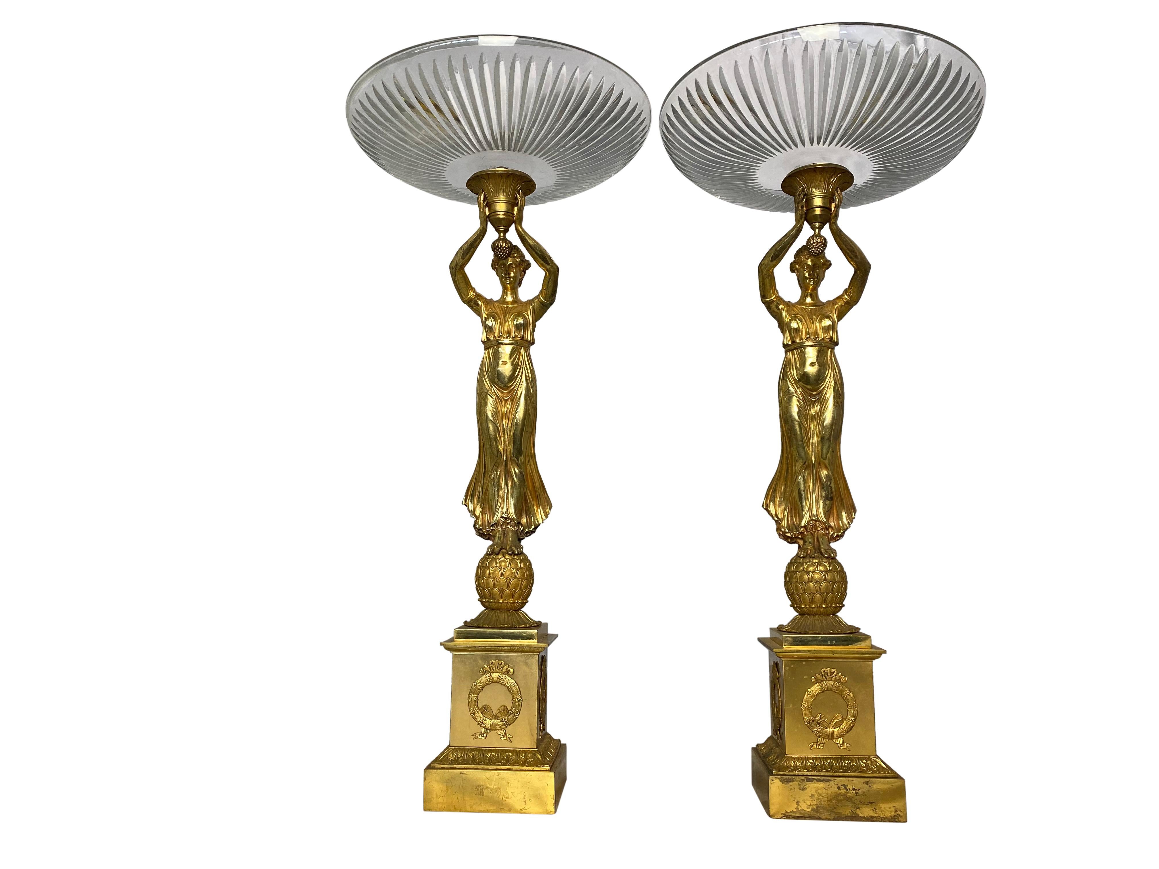 A pair of allegorical French Tazzas with cut crystal bowls suspended by Aphrodite figurative ladies, and standing on pedestal bases with detailed Empire ormolu wreaths on the walls of the plinths. Perfect for holding fruit or sweets. 20th