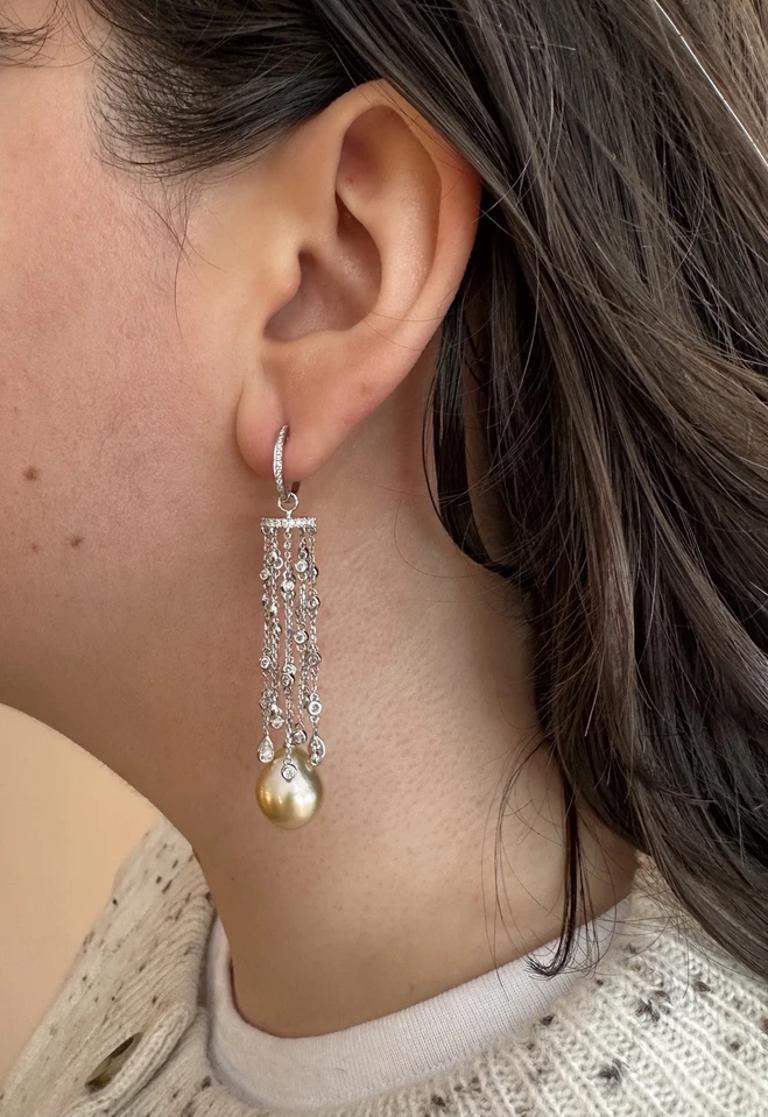Golden Pearl and Diamond Drop Chandelier Earrings in 18k White Gold

Golden Pearl and Diamond Chandelier Drop Earrings feature two Teardrop cultured Golden Pearls with a chandelier of Pave Diamond sections and Bezel set Diamonds hanging on chains