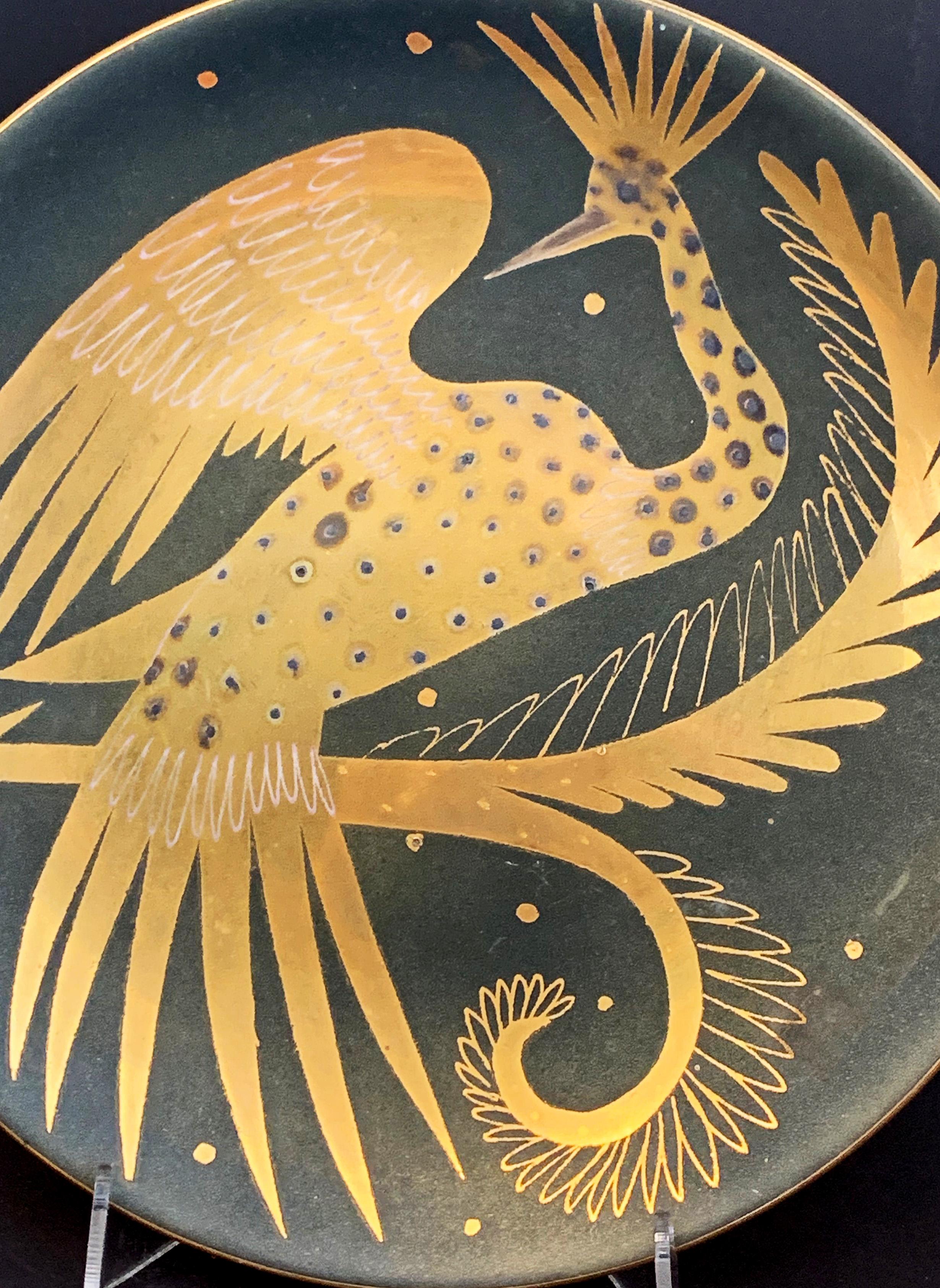 Richly finished in gold and charcoal-hued glazes, this decorative plate features a large, fantastical phoenix bird, with outspread wing, curving tail and spiky plumage. The artist was Waylande Gregory, who was prodigious and indefatigable over a