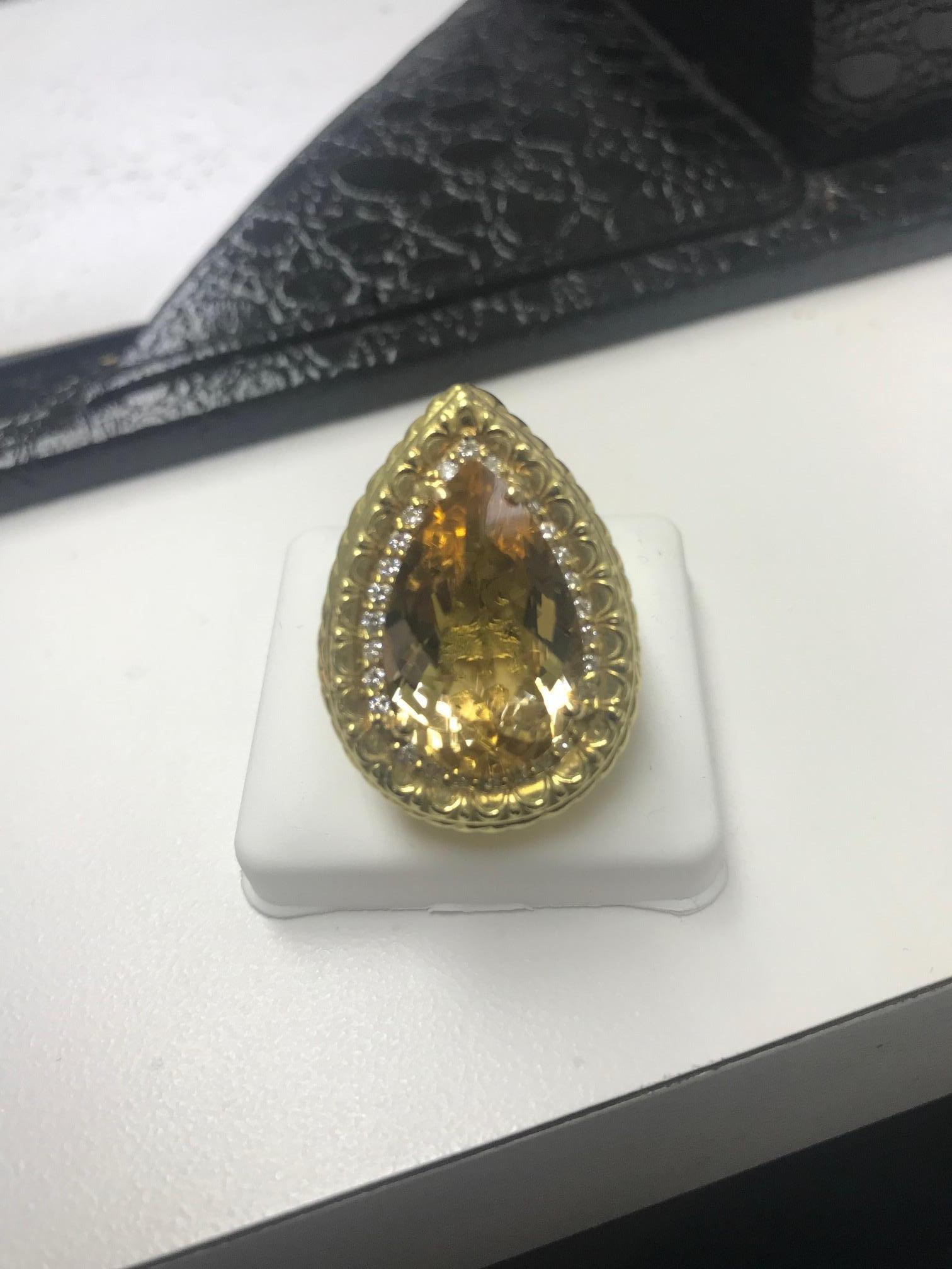 Éclat d'or - Bague en béryl jaune de 20,94ct avec 0,38ct de diamants dans une monture unique en or jaune 18 carats .
Cette bague rayonnante en béryl jaune de 20,94 carats brille d'une chaleur dorée qui capture l'essence de la lumière du soleil.