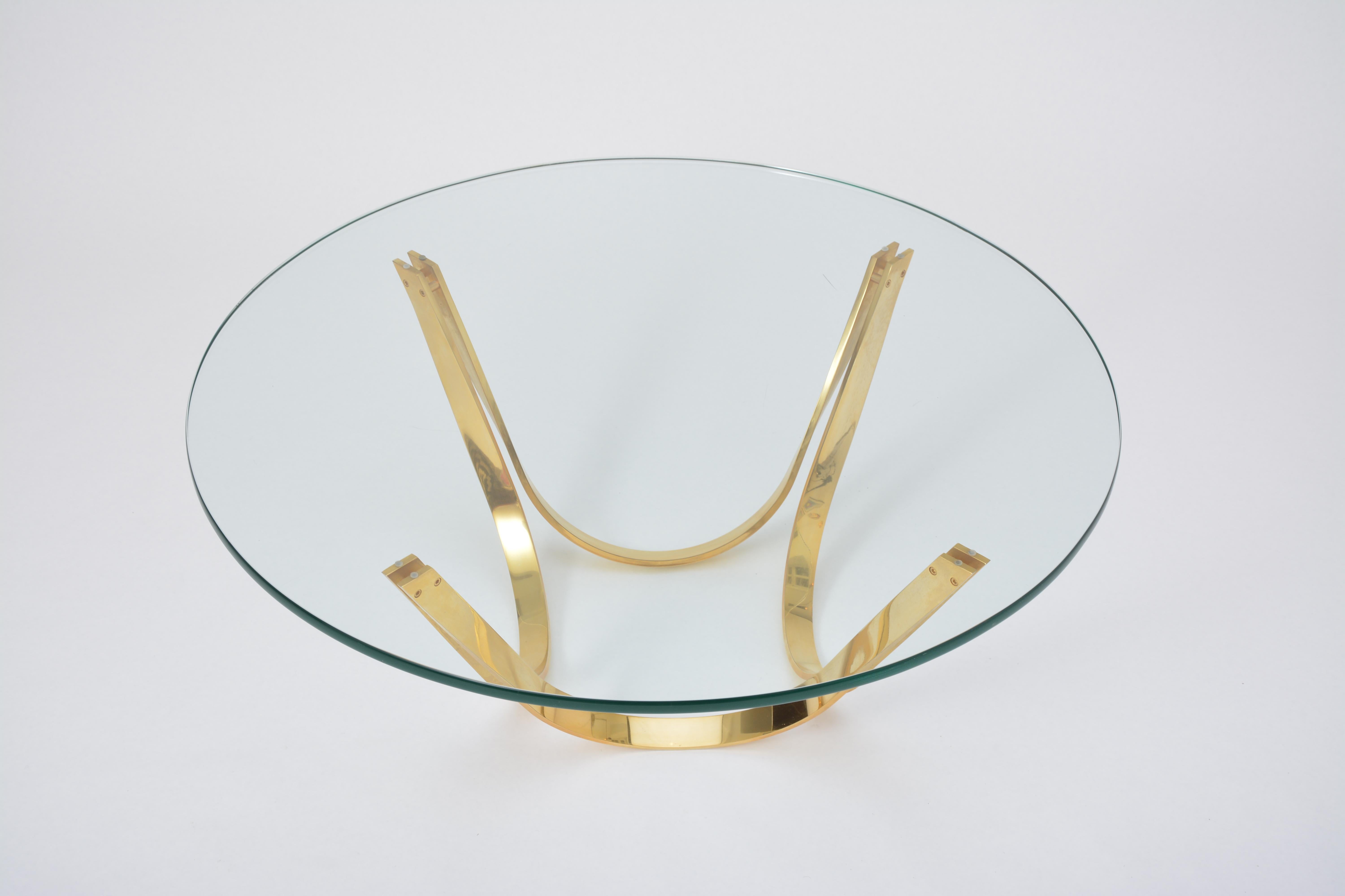 This round coffee table was designed by Roger Sprunger and produced by American company Dunbar in the 1970s. The base is made of gilded chrome steel. The top is made of thick glass.
