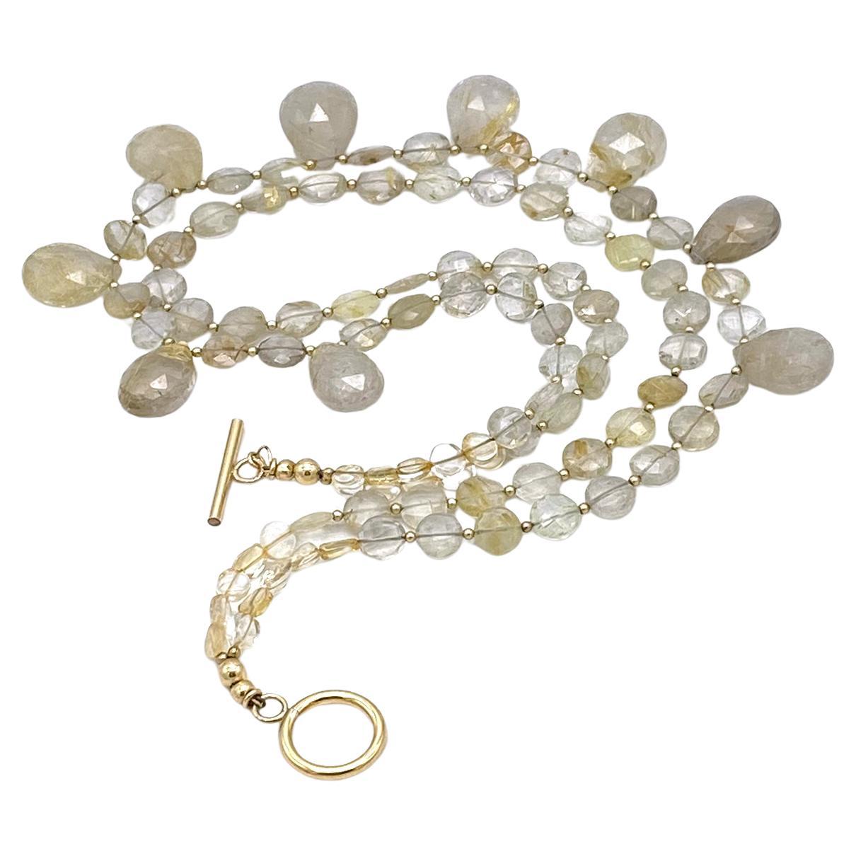 This is a golden rutilated quartz briolette necklace. We created this double strand necklace with up to 20 mm faceted pear briolettes and up to 10 mm coin shaped rutilated quartz plus a 14K gold filled toggle clasp and 1.5mm spacer beads. It's low