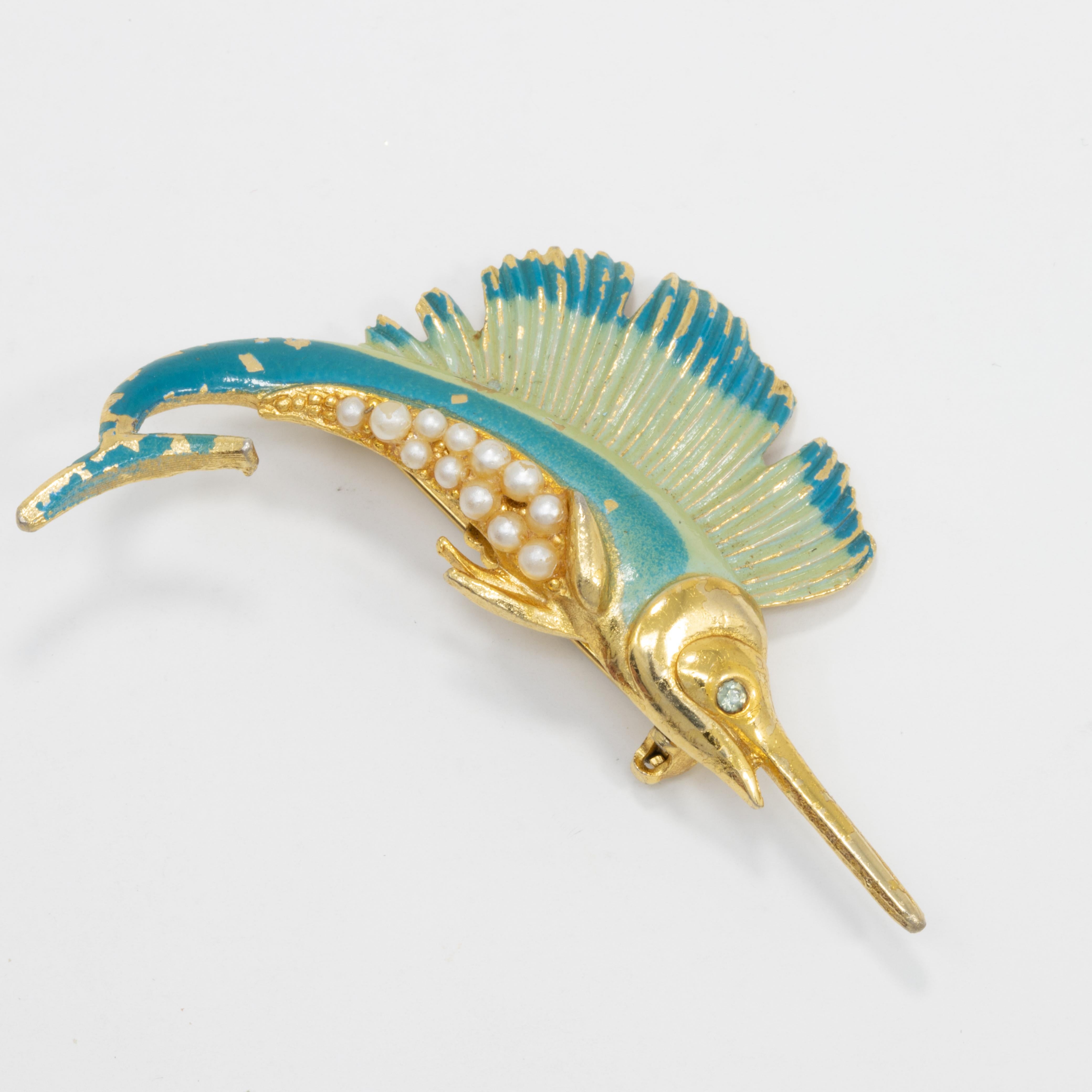 A vintage nautical pin. This gold-plated sailfish is painted with green and teal enamel, and accented with faux pearls and crystals.