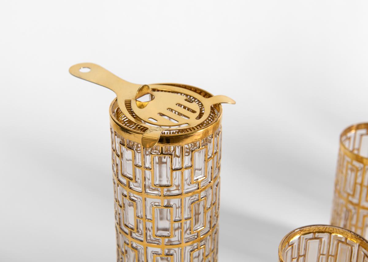 This Hollywood Regency style cocktail set glitters with 22K gold latticework in a raised, Shoji pattern, inspired by the Japanese screen. 

Marked at bottom of each glass with a C.

Mixing Glass: Height: 8.125