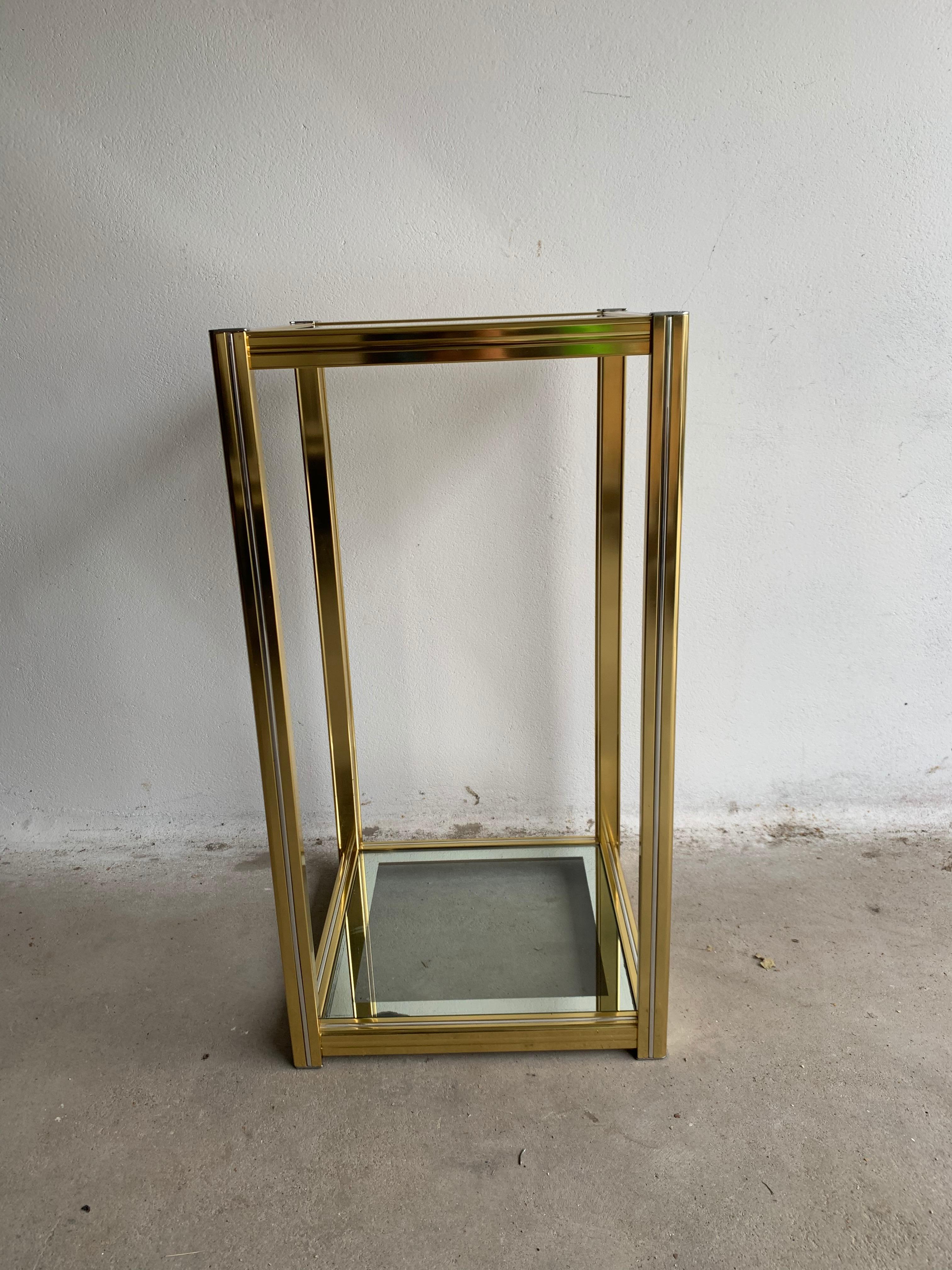 Vintage side table reminiscent of the designs by Pierre Vandel. Made of high-quality gold-plated aluminum with mirror edges on the glass tiers. Hollywood Regency style. Pierer Vandel is best known for his angular tables, which exude the glamorous