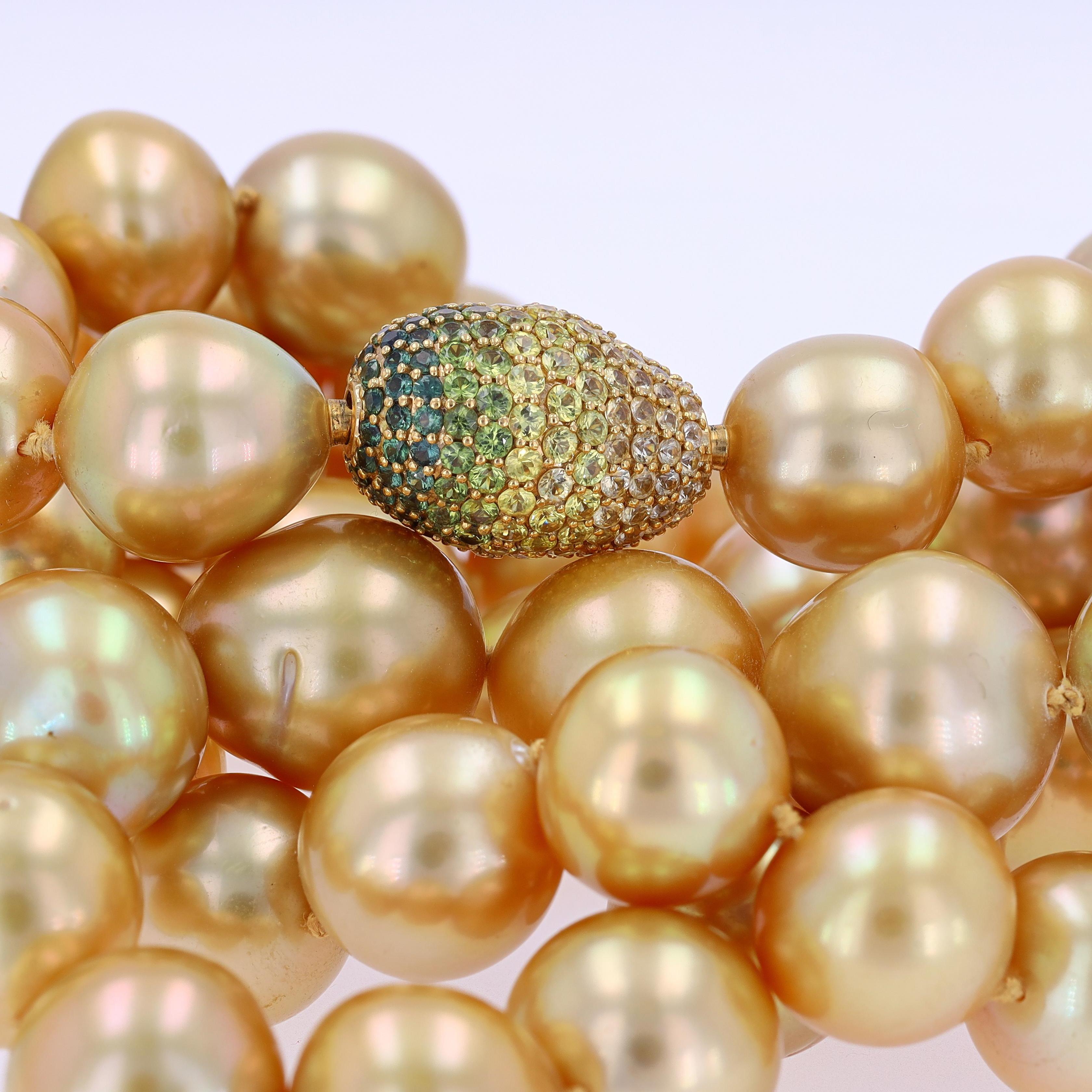 Strand of golden cultured South Sea pearls measuring approximately 15.5 to 12.5 mm, with an ombré green & yellow pavé-set sapphire pebble clasp, mounted in 18K gold. The necklace measures 36.5 inches in length.

Description:
These pearls are golden