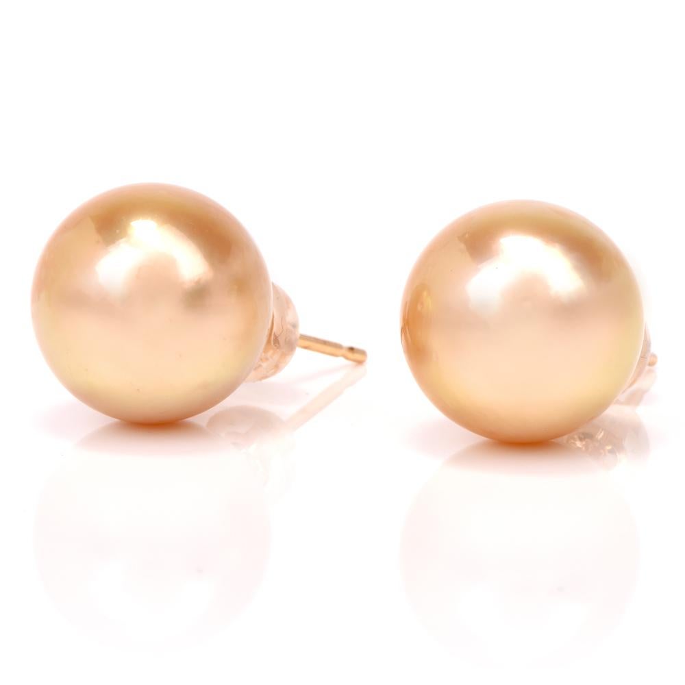 These South Sea golden pearl stud earrings are crafted in solid 18K yellow gold. They incorporate a pair of 12.0 mm South Sea pearls of outstanding lustrous high nacre with natural golden color. The earrings feature posts and butterfly clasps,