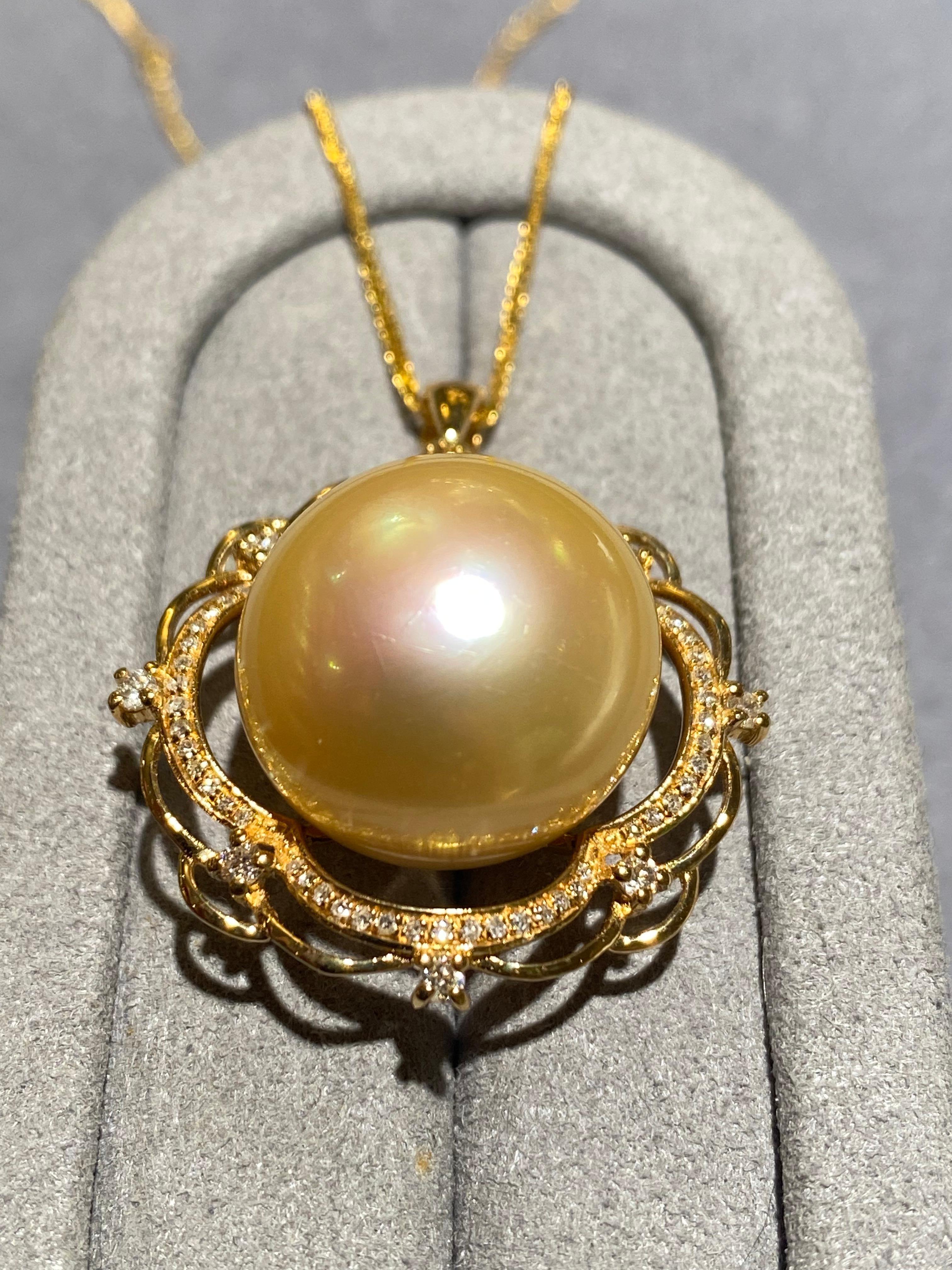 Une perle dorée des mers du Sud de 17,2 mm est sertie au centre d'un pendentif à motif floral en or jaune 18 carats. Huit diamants sont sertis sur le pourtour du pendentif. Le cercle intérieur du pendentif est cependant serti d'un cercle de micro