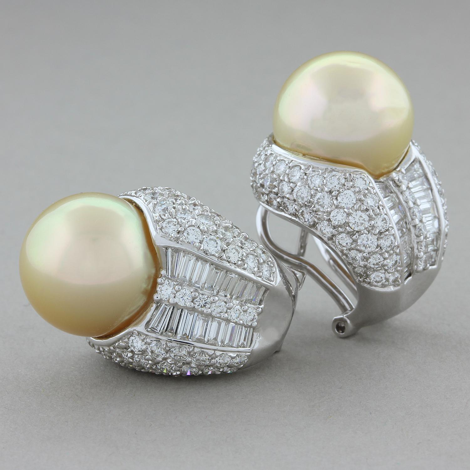 Questo splendido paio di orecchini presenta due perle tonde dorate dei Mari del Sud abbinate. Queste perle dorate da 12,5 mm sono circondate da 4,04 carati di diamanti taglio rotondo VS e diamanti taglio baguette in una montatura a canale che crea