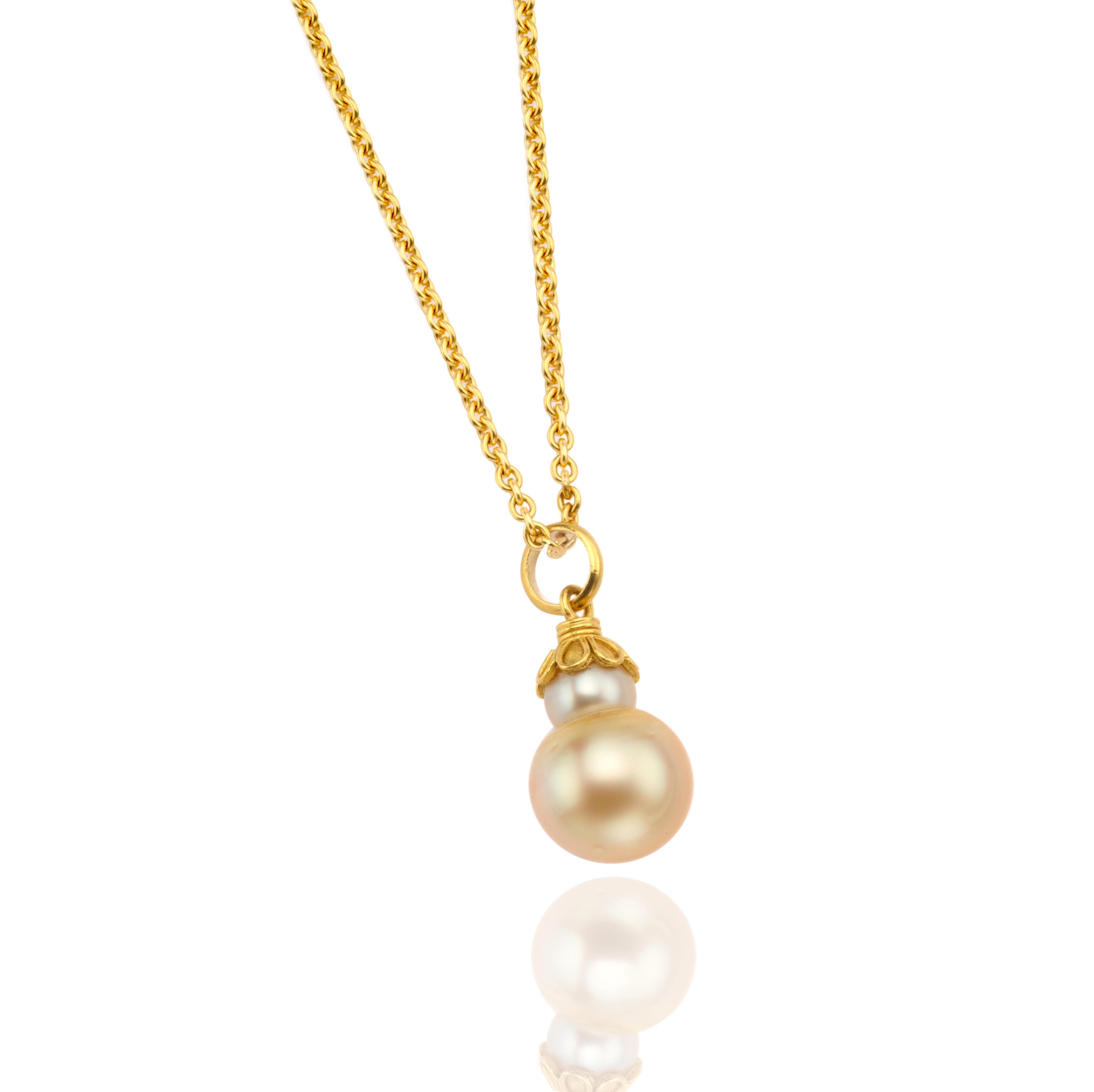 Very lovely double Golden South Sea pearl mounted in 22 karat gold cap. Being the most rare and sought after, South Sea pearls are known for their incredible size and beautiful satin lustre. The pearl measures 13mm in diameter. Shown on small 22
