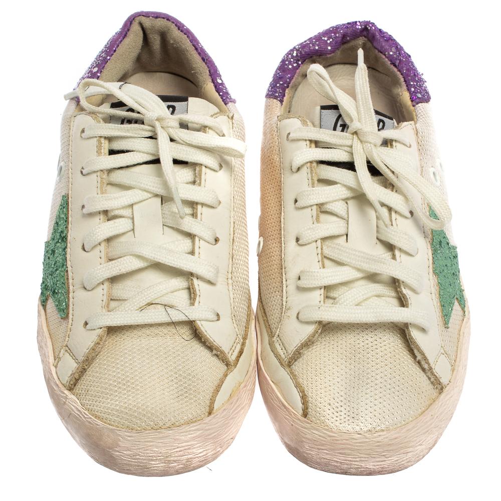 Founded in 2000, Golden Goose is hailed for meticulous craftsmanship in shoemaking and creative designs fused with a vintage appeal. Made from knit fabric and leather in a white hue, they feature a distressed finish, laces on the vamps, and
