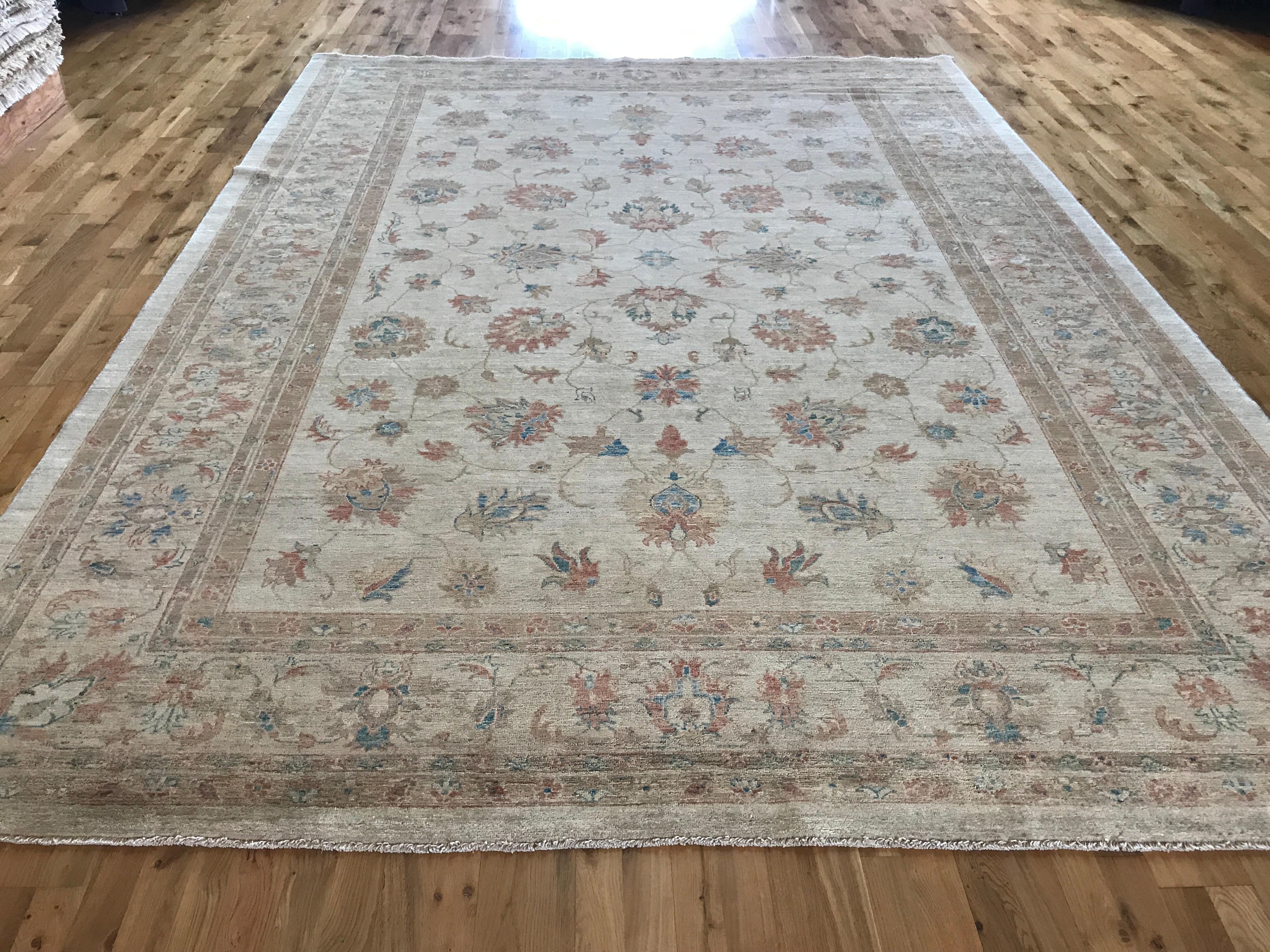 Lovely warm tan traditional style area rug with floral motif using teal, brown and rust colors. Durable all wool-construction. Hand knotted in Pakistan.