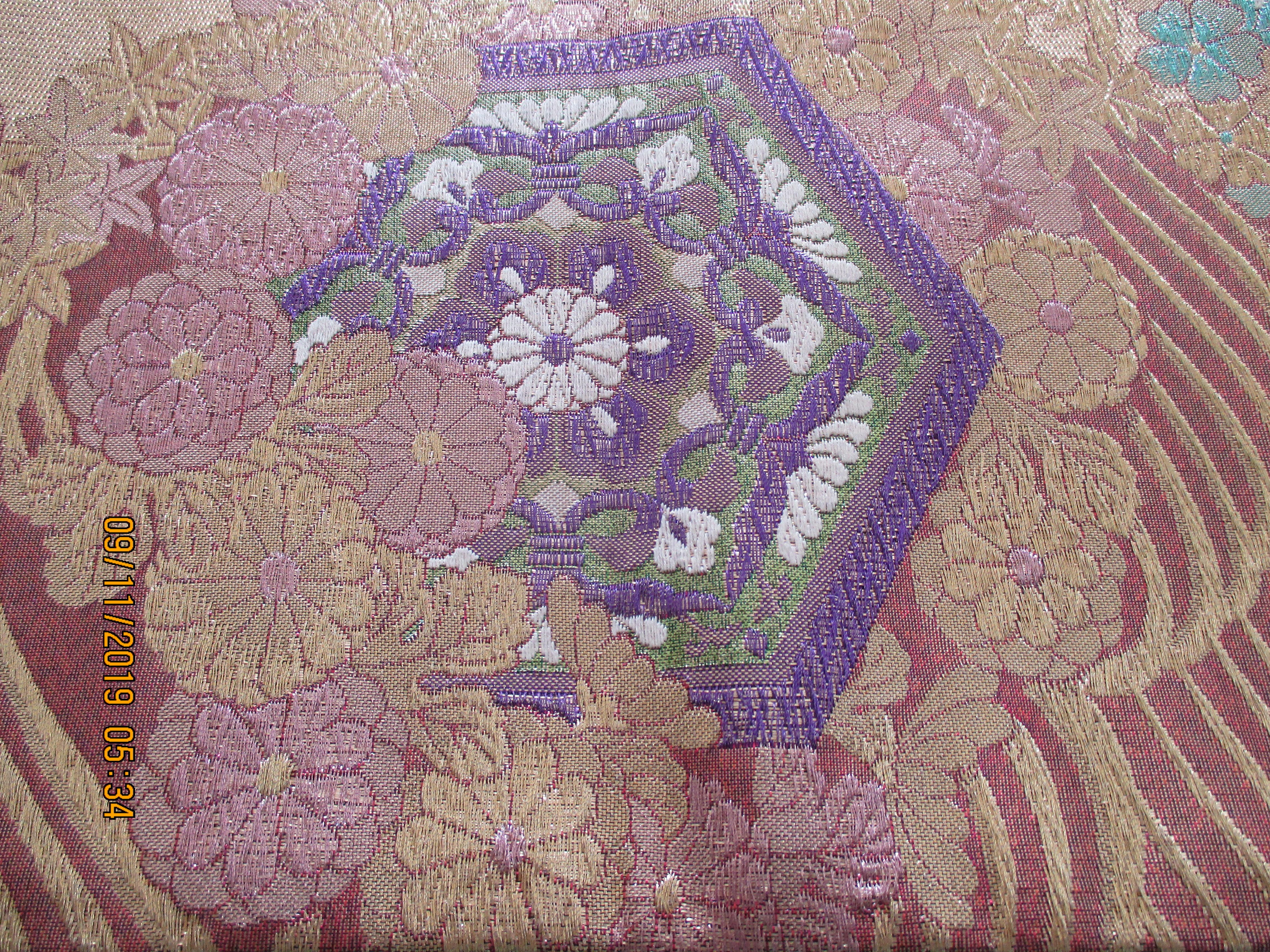 Golden textured woven Obi textile depicting flowers in bloom,
in shades of deep purple, gold, lavender, green, white, pink and aqua
Ideal for pillows or upholstery.
Size: 12