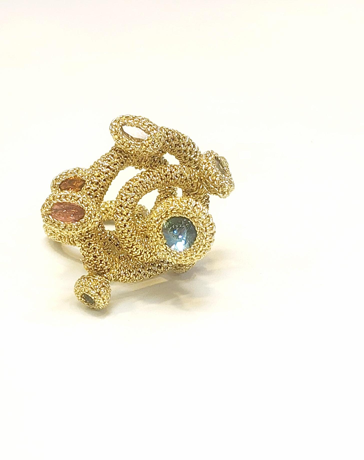 This is a very unique ring. I call it my galaxy ring. It is crochet around a metal wire which I then shaped into a spiral. I then added Swarovski crystals to enhance the movement of this beauty. The thread is a light gold smooth passing thread. 