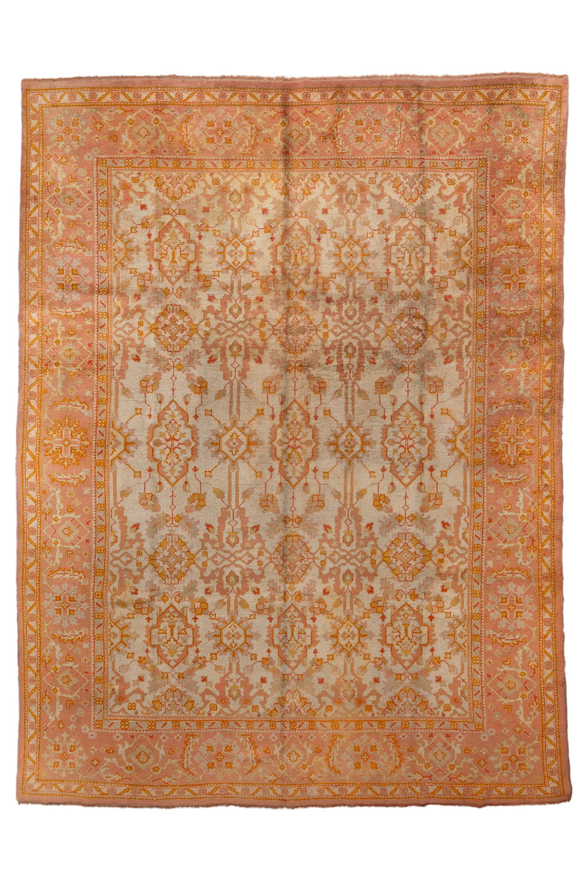 The straw-ecru field of this western Anatolian city carpet shows  five column, five full row,  pattern of open, pointed cartouches,  stepped lozenges and other unusual elements, all accented in goldenrod,  rust and green. Boder of  large rosettes,