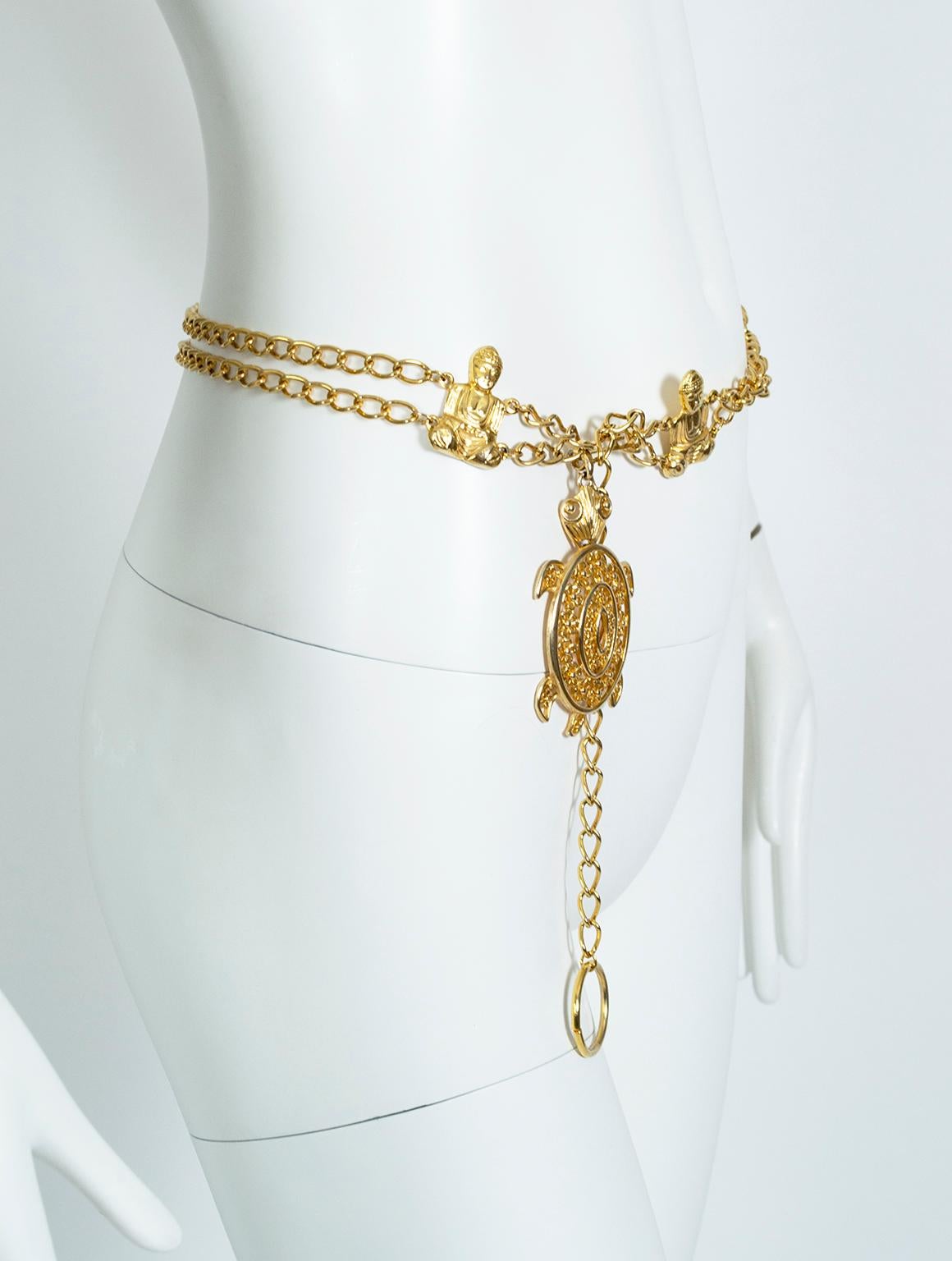 A striking and unusual beauty, this chain belt features figural Buddhas and a large dangling filigree turtle, both of which commemorate the life and spirituality of Buddhist monks. Believed to possess divine powers, turtles represented wisdom and