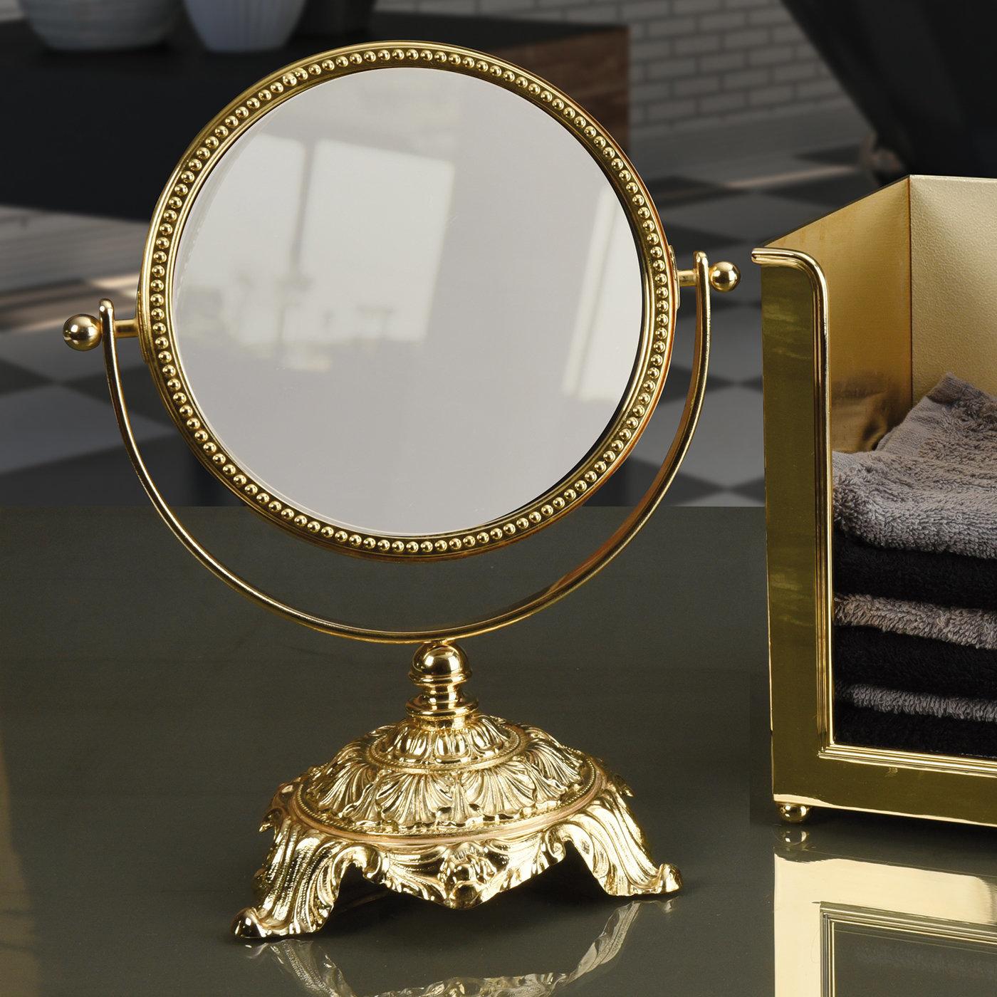 Aesthetic refinement and traditional craftsmanship merge in this lavish mirror, a superb complement to an opulent vanity table. Handcrafted of brass and finished with 24k galvanized gold, it features a classic round shape mounted on an upward
