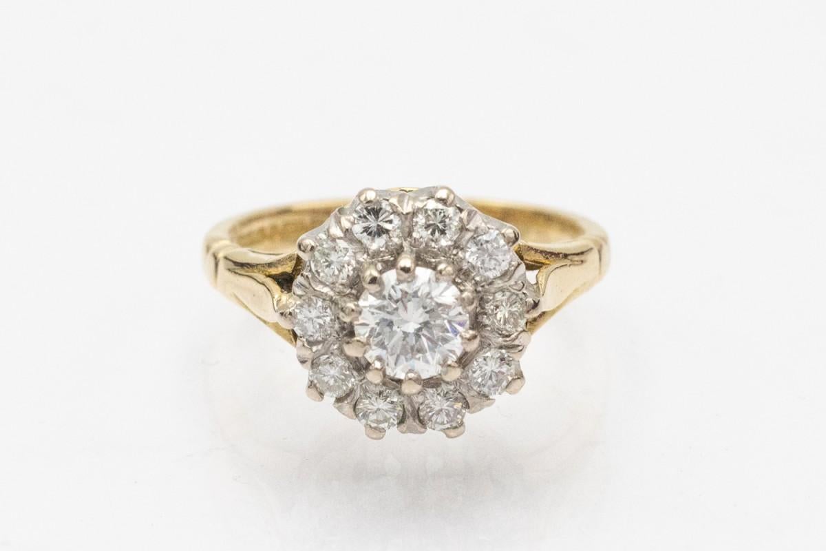 Bague unique en or 18 carats (750). Son point central est un diamant taille brillant pesant environ 0,50ct, entouré de 10 diamants taille brillant d'un poids total de 0,50ct.

Origine : Grande-Bretagne, Sheffield, 1989.

Taille : 52 - demandez la