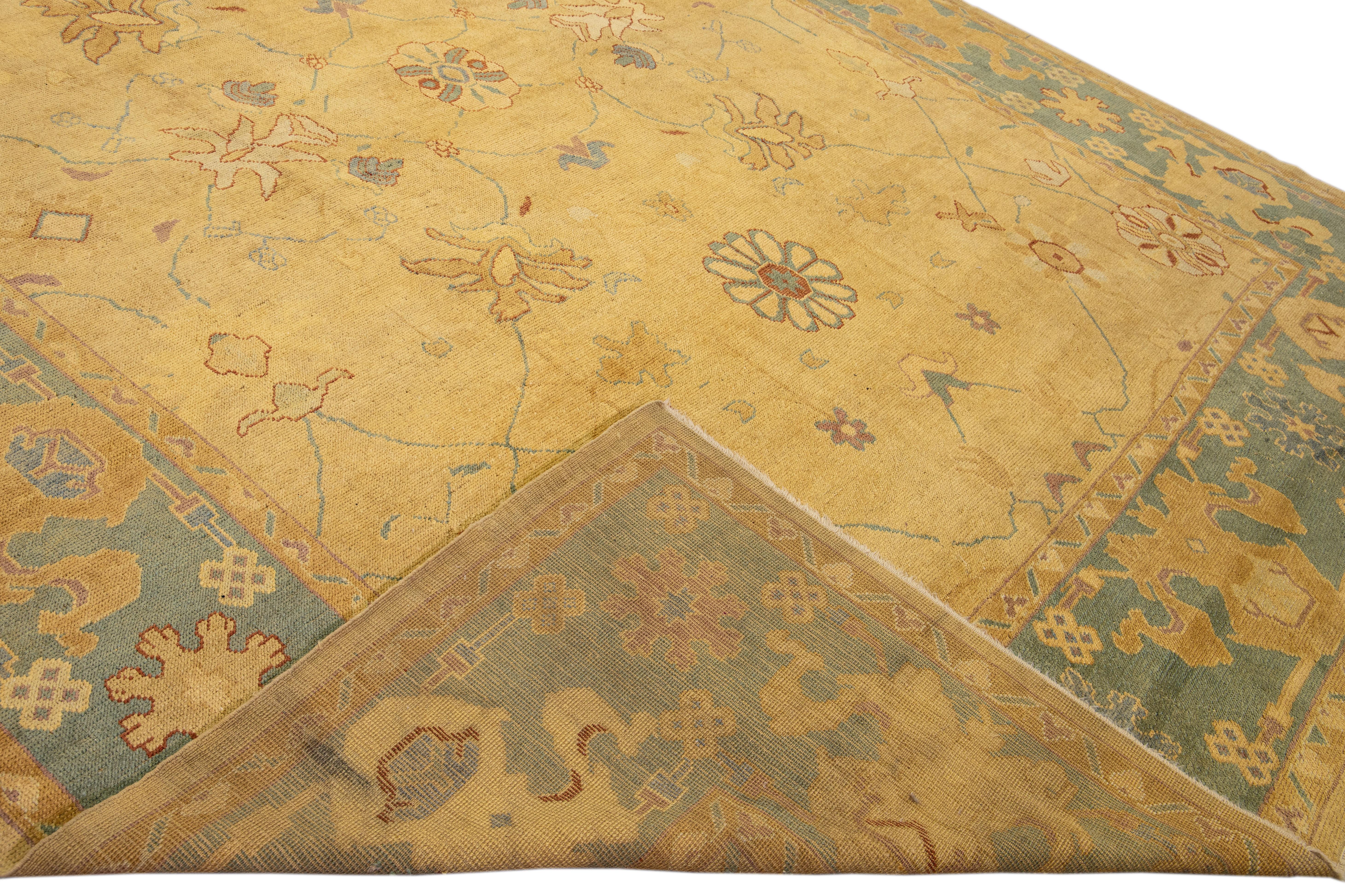 Beautiful modern Oushak hand-knotted wool rug with a goldenrod field. This Oushak rug has a green frame and multicolor accents that feature a gorgeous floral pattern design.

This rug measures: 11'4