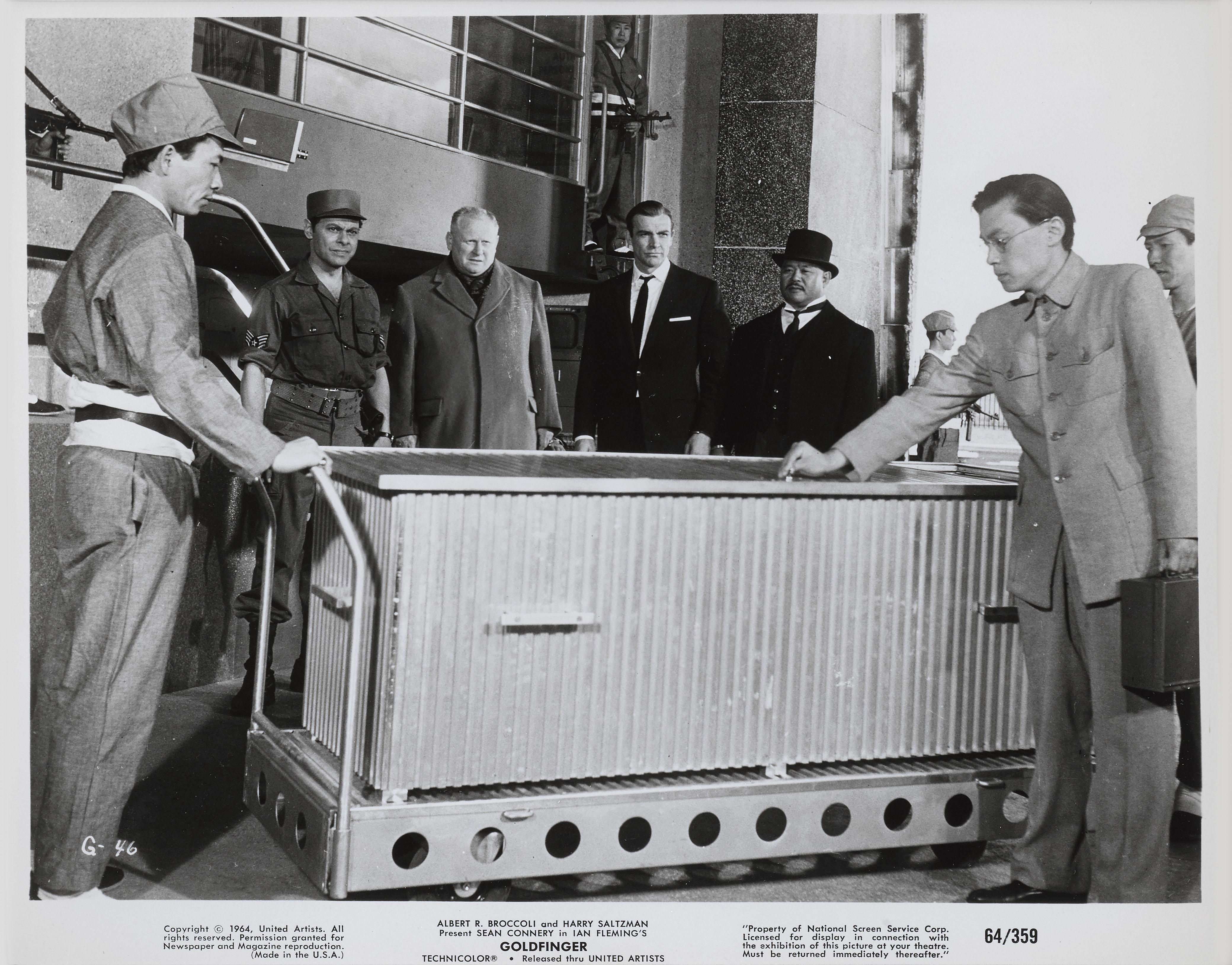 Photo originale du film Goldfinger de James Bond, 1964. 
Ce site  est le troisième film de James Bond et la troisième fois que Sean Connery incarne 007. Cette pièce est encadrée dans un cadre en bois de Sapele avec des cartons sans acide et du