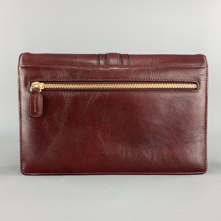 burgundy and gold clutch bag