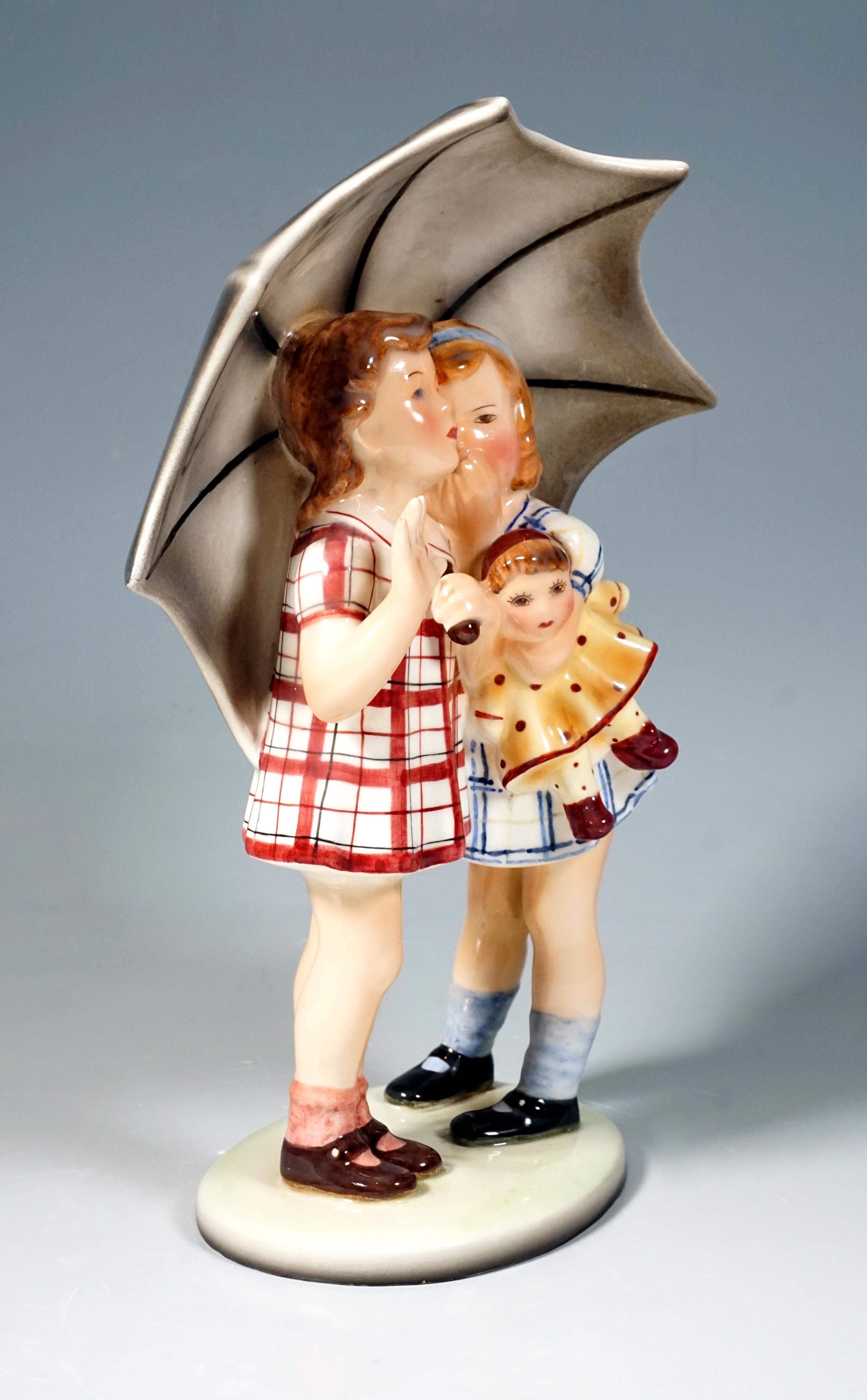 Two girls under a large umbrella, in short dresses, one holding a doll tucked under her arm, whispering something in the other's ear.
On a light oval base.

Designed by STEPHAN DAKON (1904 - 1992), one of the most important designers who worked