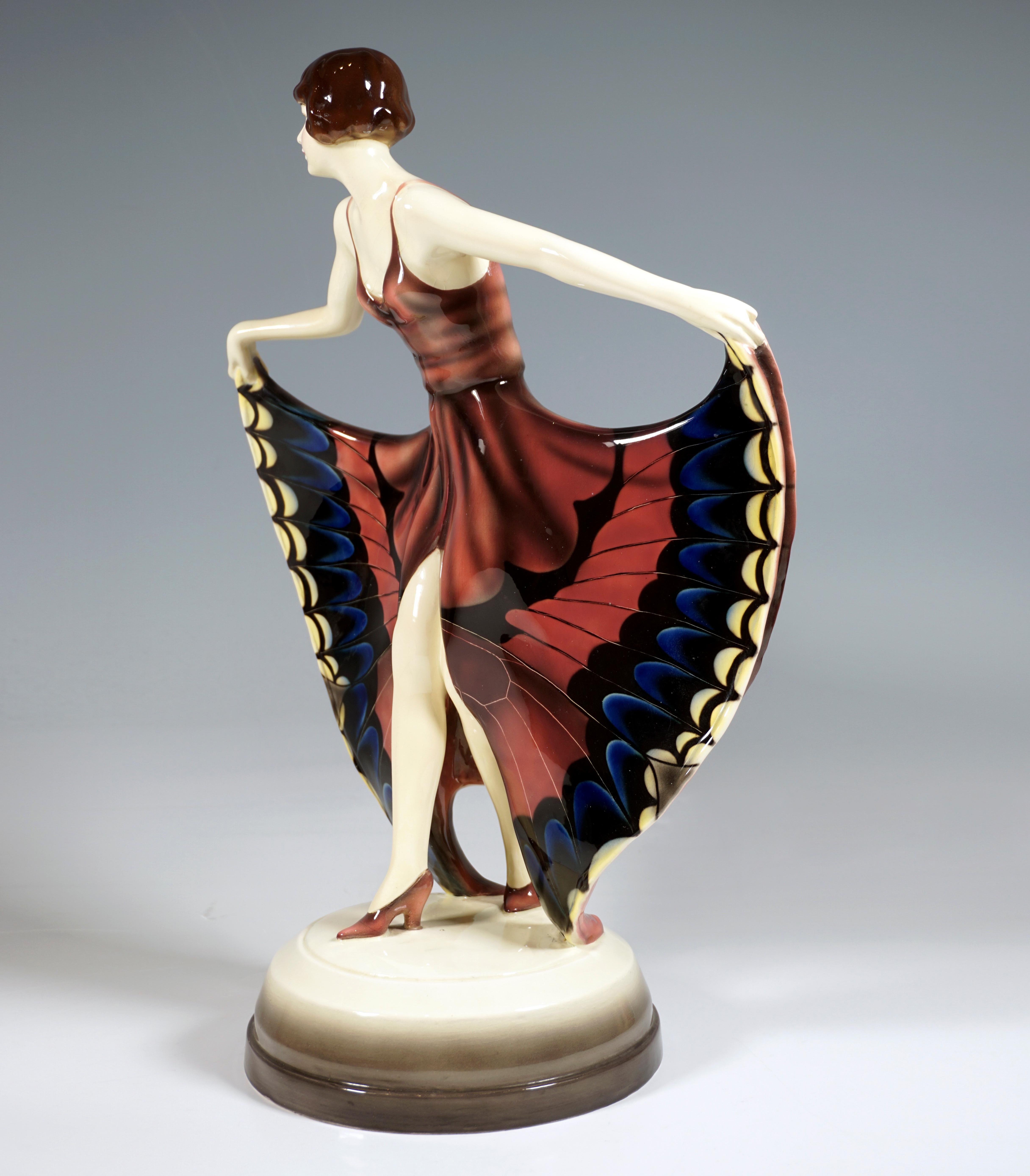 Rare Goldscheider Art Deco ceramic figure of the 1920's: 
Young dancer with pageboy hairstyle, leaning slightly forward and looking to the right, putting her right leg forward and holding the high slit skirt with butterfly decoration like wings